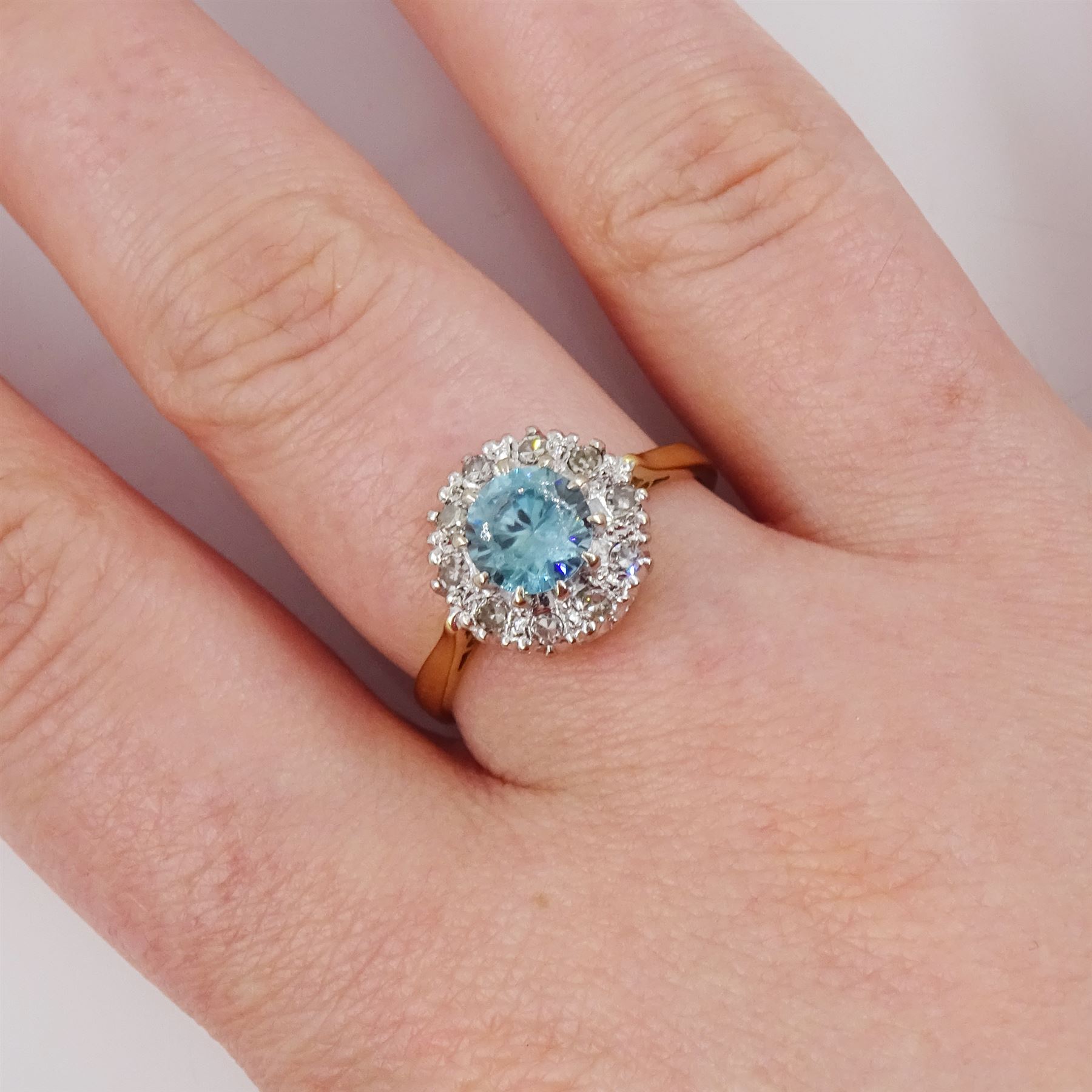 18ct gold blue zircon and diamond cluster ring, single round cut blue zircon surrounded by ten single cut diamonds, London 1965