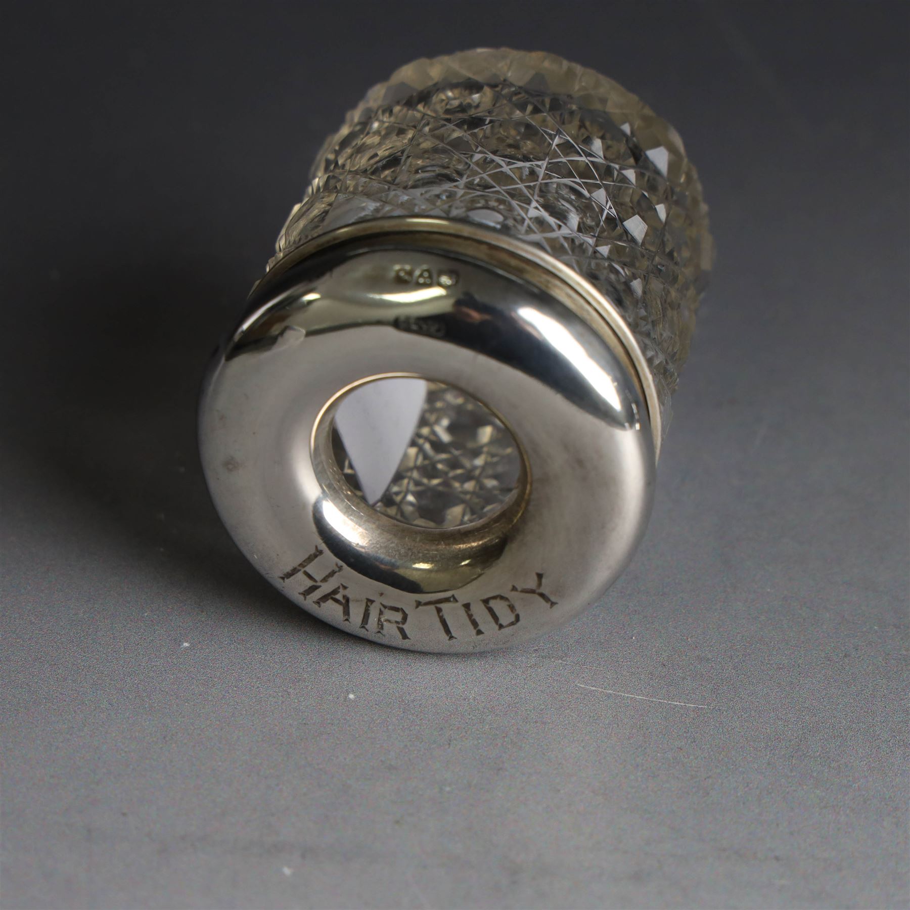 Edwardian silver fall-front ring box with loop handle, opening to reveal velvet interior with five ring spaces, hallmarked Deakin & Francis, Birmingham 1907, together with a cut glass jar with silver lid inscribed 'Hair Tidy' and a silver mounted capstan inkwell, both hallmarked 