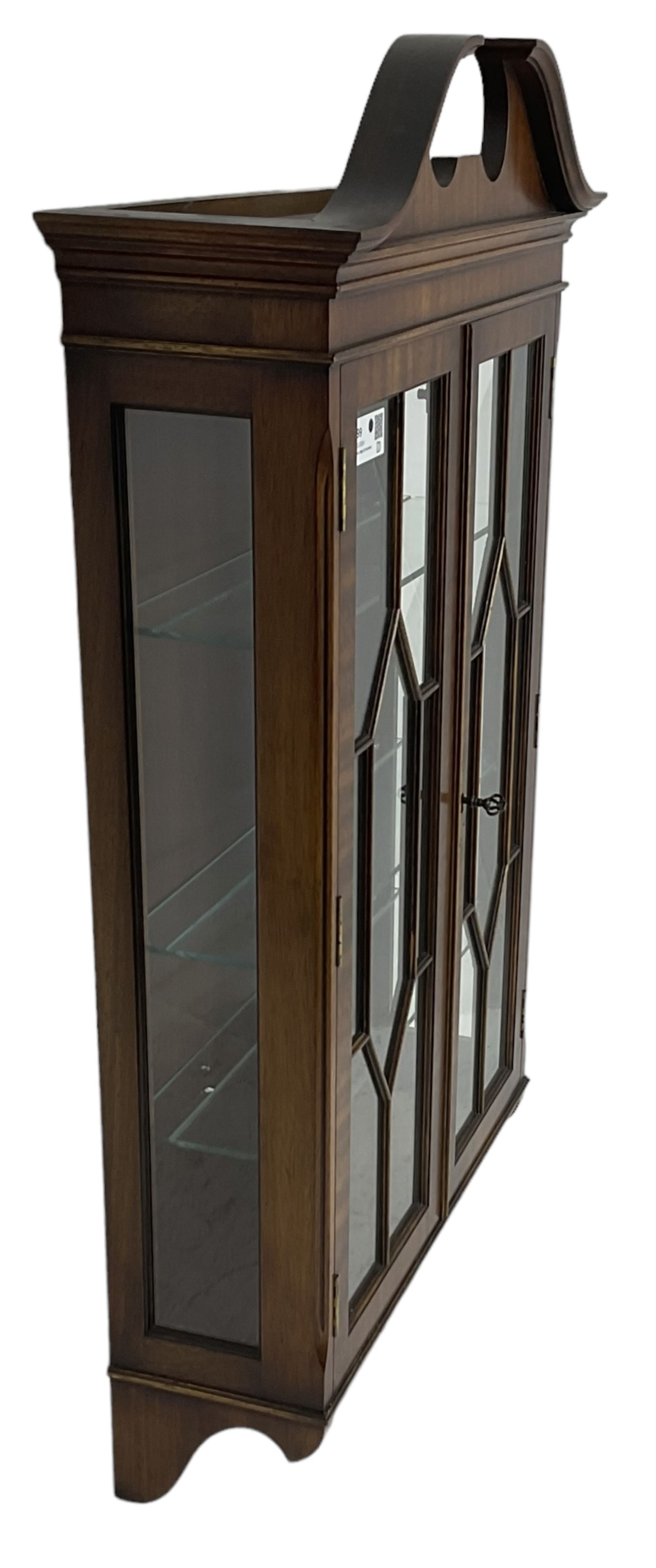 Georgian design mahogany wall hanging display cabinet, broken moulded swan neck pediment over two astragal glazed doors, the interior fitted with three glass shelves