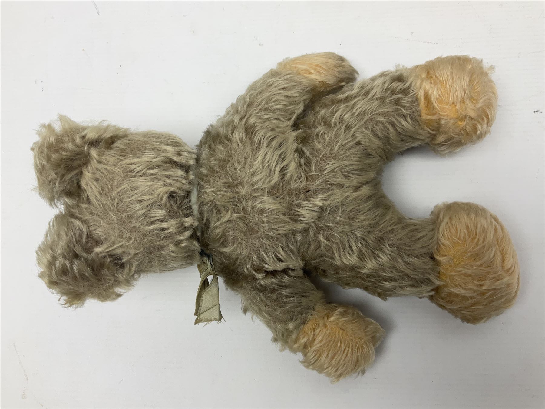 Steiff teddy bear with golden plush body, revolving head, applied eyes, vertically stitched nose and mouth and jointed limbs; button to left ear H26cm; and two other Steiff teddy bears, each with open mouth and button with tag to left ear (3)
