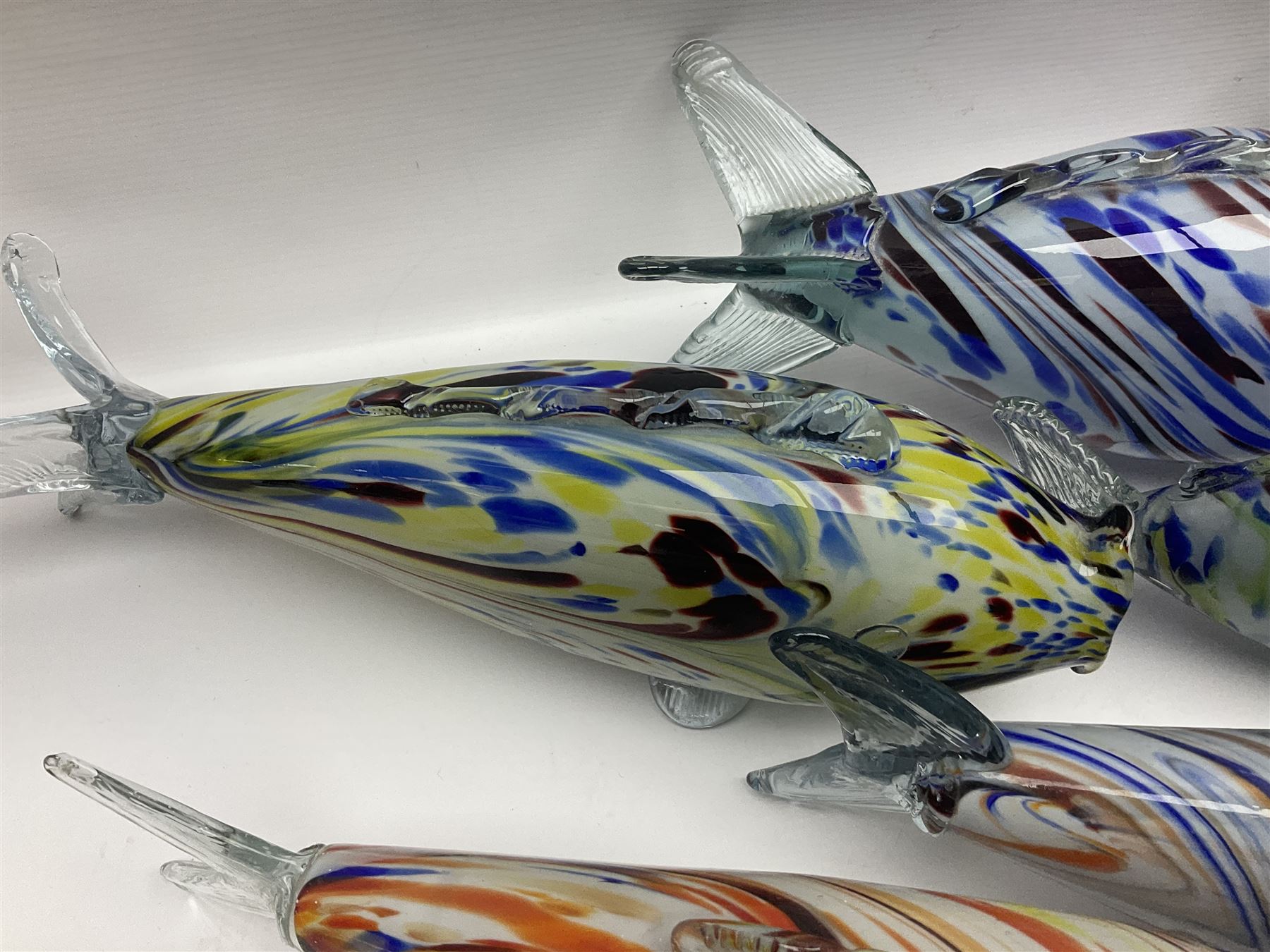 Collection of mid 20th century murano style glass fish, each with multi coloured inclusions largest L42cm
