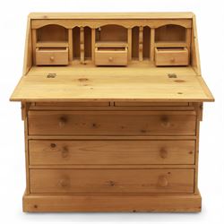 Contemporary waxed pine bureau, fall front enclosing fitted interior with pigeonholes and drawers, over two short and three long drawers with turned wooden knobs, on plinth base