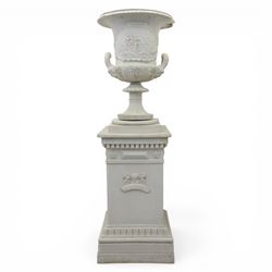 Pair of composite campana urns on stands, the urns decorated with relief figural panels and foliate bands with scrolling handles, on circular socles, the pedestals of square tapering form with moulded edges and applied classical motifs