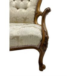 Victorian walnut framed drawing room open armchair, the cresting rail and arm terminals decorated with scrolling acanthus leaves, buttoned back and sprung seat upholstered in beige damask fabric, raised on cabriole supports decorated with applied foliate decoration 