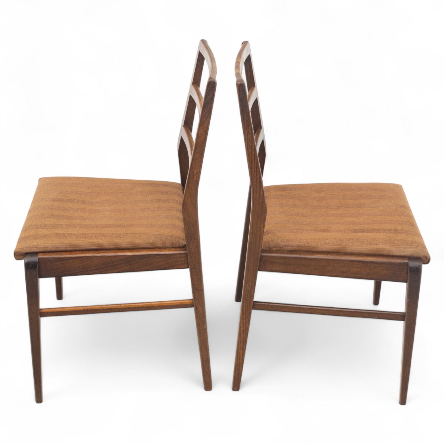 Richard Hornby for Fyne Ladye - mid-20th century afromosia teak dining table, tapered rectangular top with fluted edge and recess for spare leaf, raised on slender legs, four teak framed chairs, of ladder back design, with drop-in seat, upholstered seat, with tapered front legs and slightly raked rear legs,, table unextended width 106cm depth 79cm height 74cm with additional leaf 45cm wide- chairs width 48cm depth 41cm height 87cm 