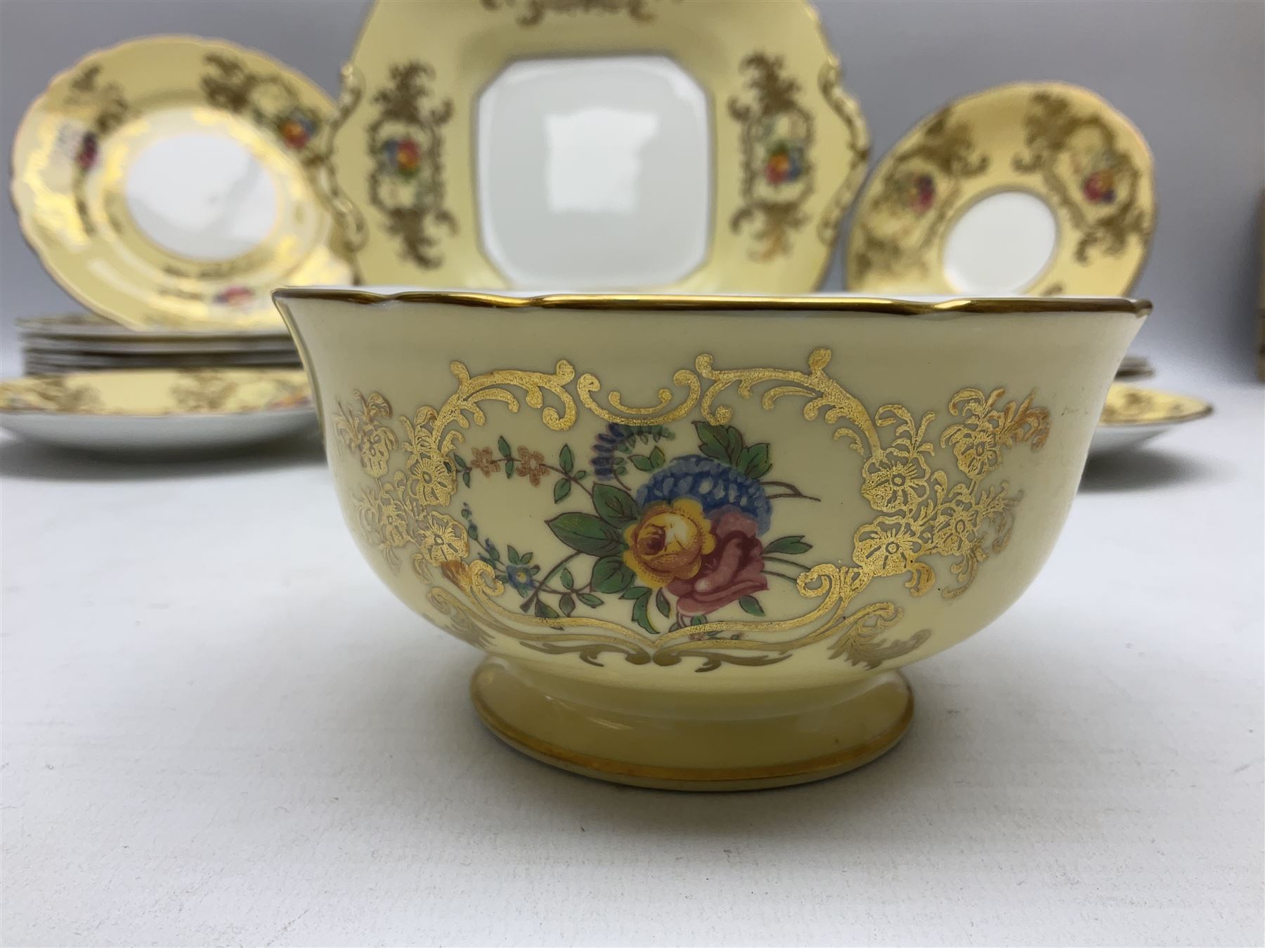 Aynsley tea service for six, decorated with floral sprays in ornate gilt detailing on cream ground, comprising six teacups and saucers, open sucrier and milk jug and cake plate, all with printed marks beneath