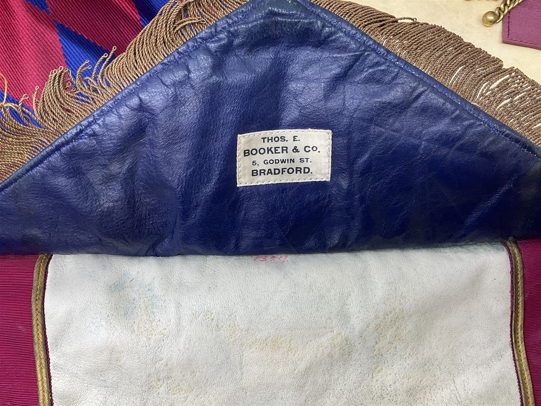 Two Masonic kid leather aprons, one with sash and cuffs, the other with sash, each marked 'Yorkshire North and East Ridings'; and three other unmarked Masonic aprons with sashes