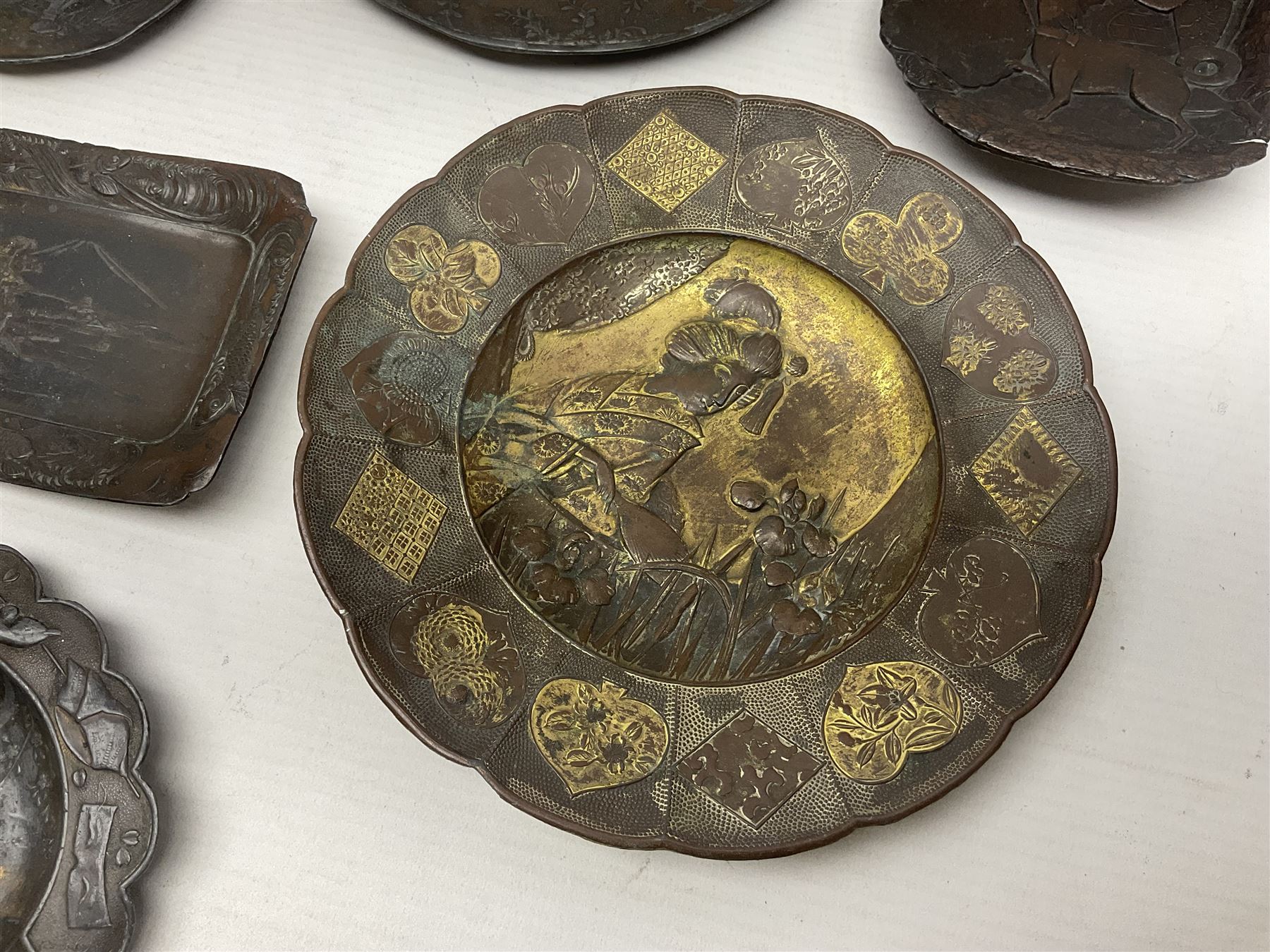 Brass sunfish ashtray, Chinese silver plated trinket box with mirror, bronzed matchbox cover and a collection of other Oriental bronzed embossed metal trays