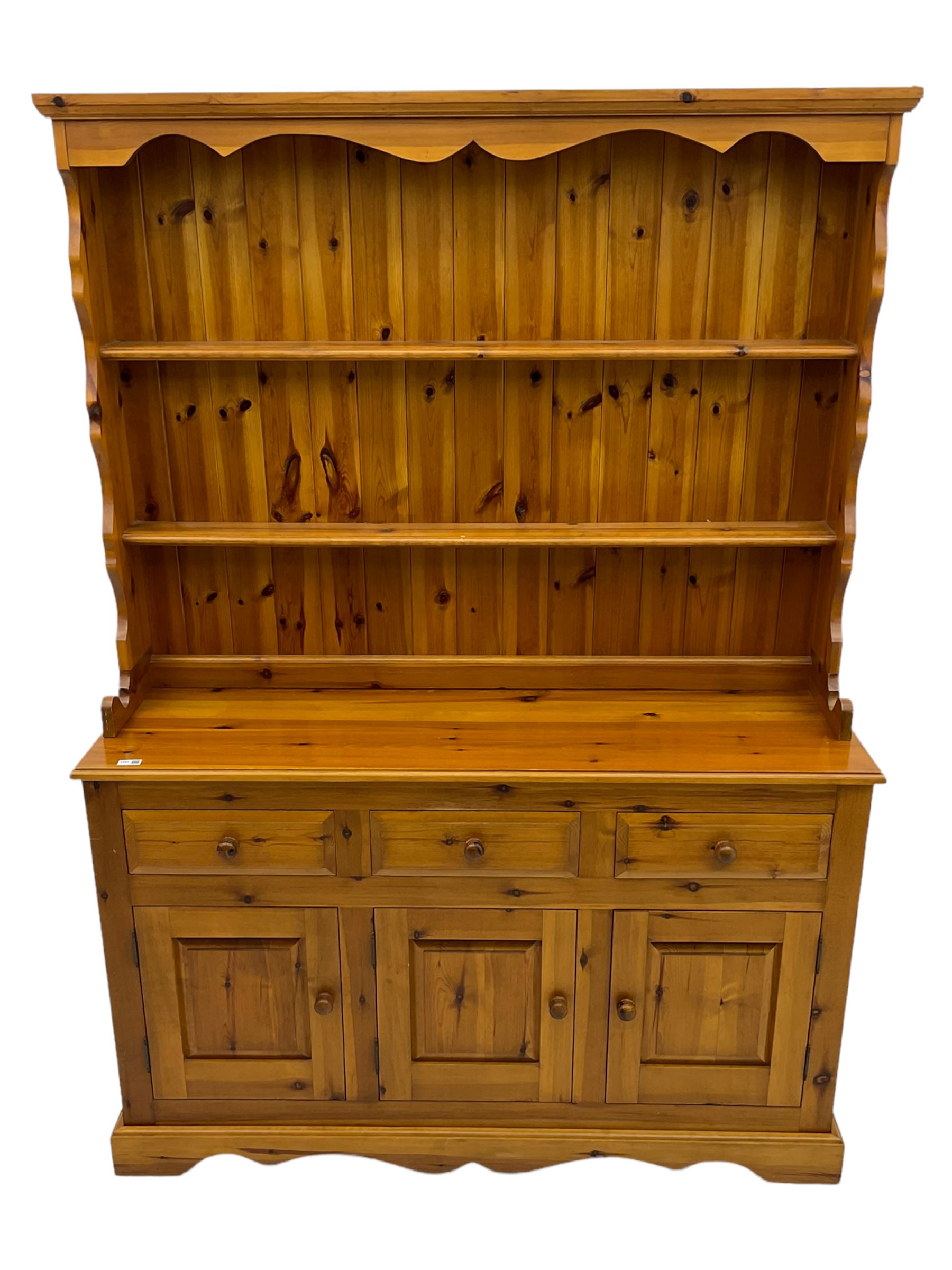 Pine farmhouse dresser with three drawers and three cupboards, and two tier plate rack