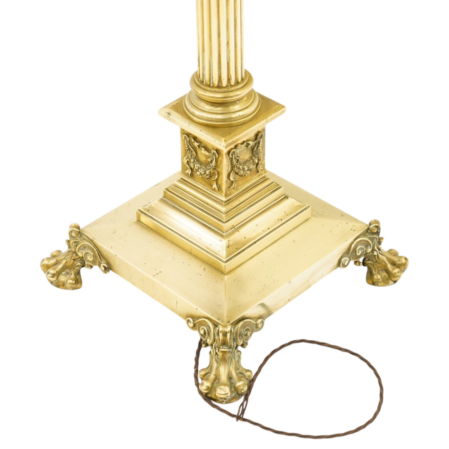 Late Victorian Neoclassical brass standard lamp with shade, the composite Ionic and Corinthian acanthus capital over a reeded column, terminating to a stepped platform base with applied festoon ornament, raised on four scrolling ball-and-claw feet