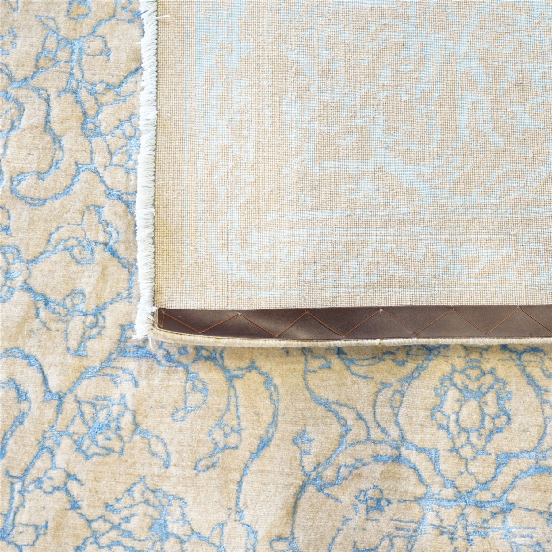 Large cream ground carpet, with overall arabesque design in light blue, within scrolling border 