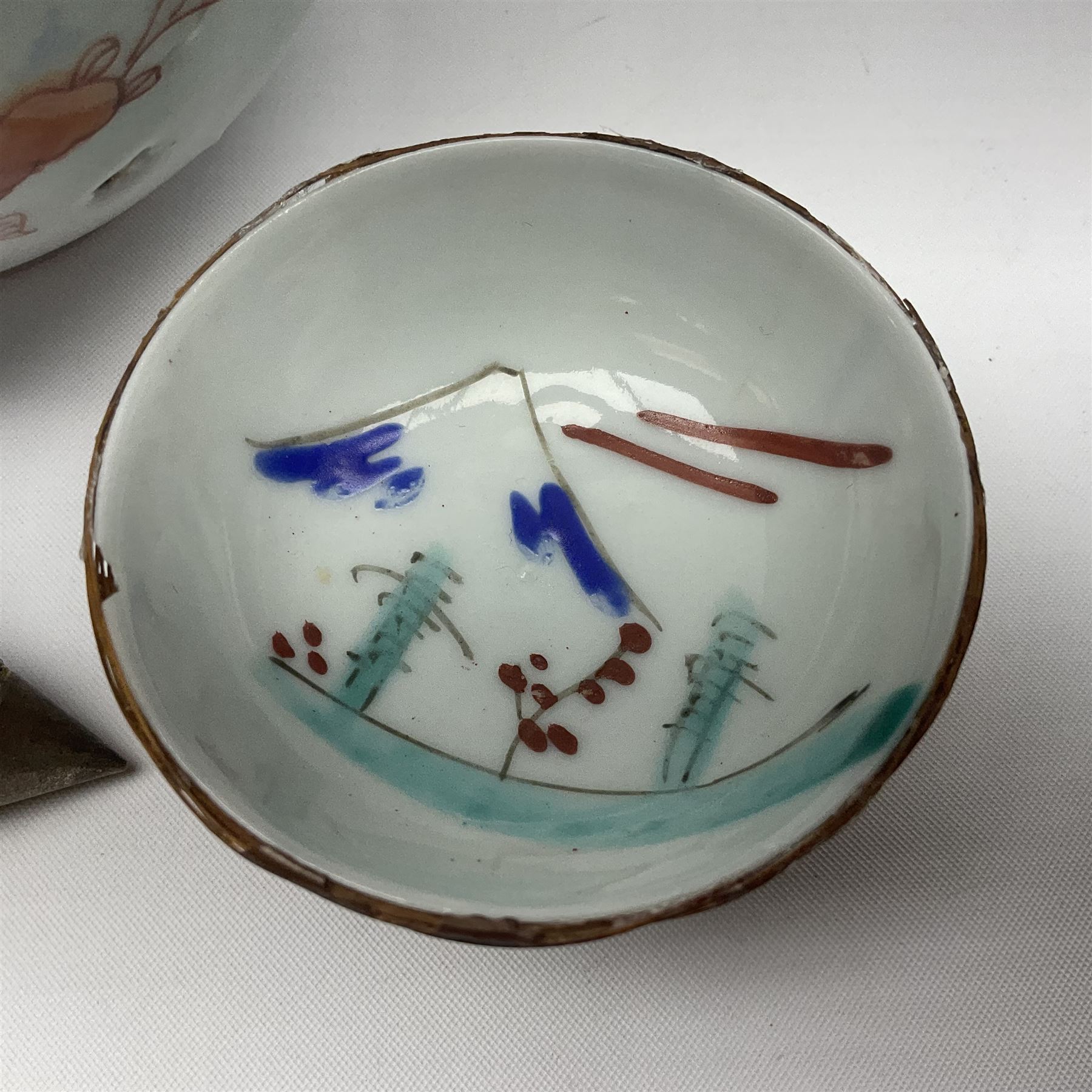 Chinese ceramic bowl, painted with floral and foliate decoration on a white ground, together with a similar much smaller Chinese bowl, painted with mountain scene to centre and covered by basket weave to exterior and a white metal mounted pear shaped scent bottle, largest bowl D11cm
