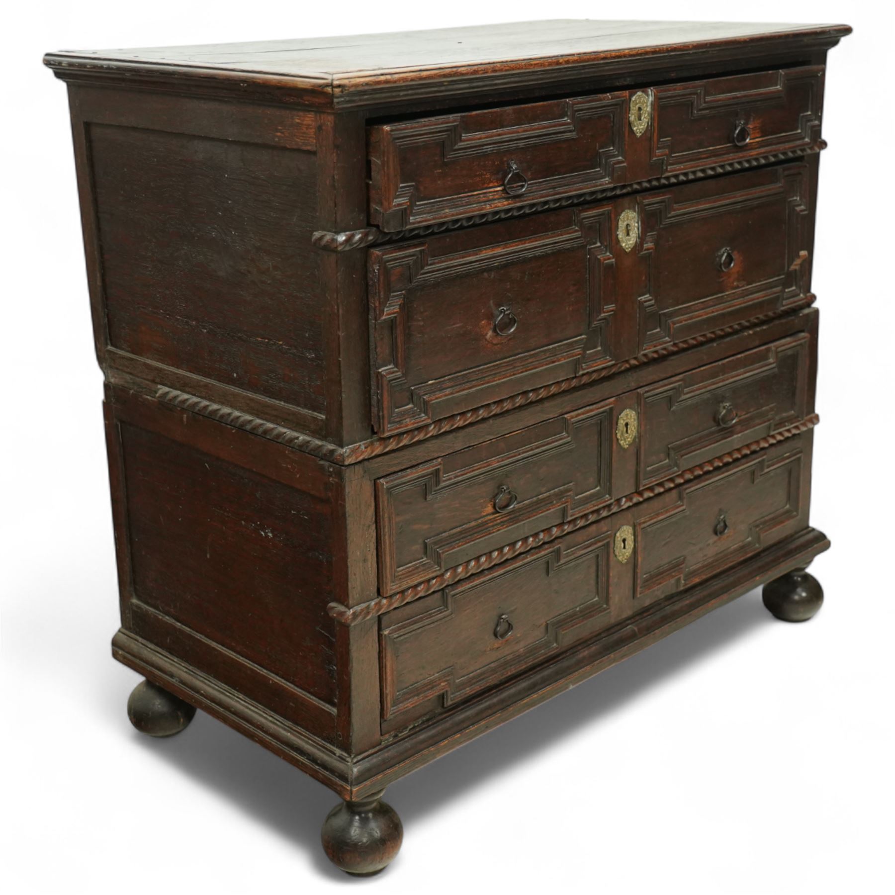 Late 17th-century oak chest, rectangular top above four graduated drawers with geometric panel mouldings, in two sections, supported on bun feet 