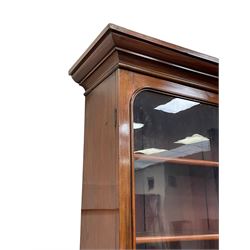 Victorian mahogany library bookcase on cupboard, projecting moulded cornice over two glazed doors in arched frames with moulded slips, fitted with four adjustable shelves, the cupboard with moulded rectangular top over two panelled arched doors, moulded plinth base
