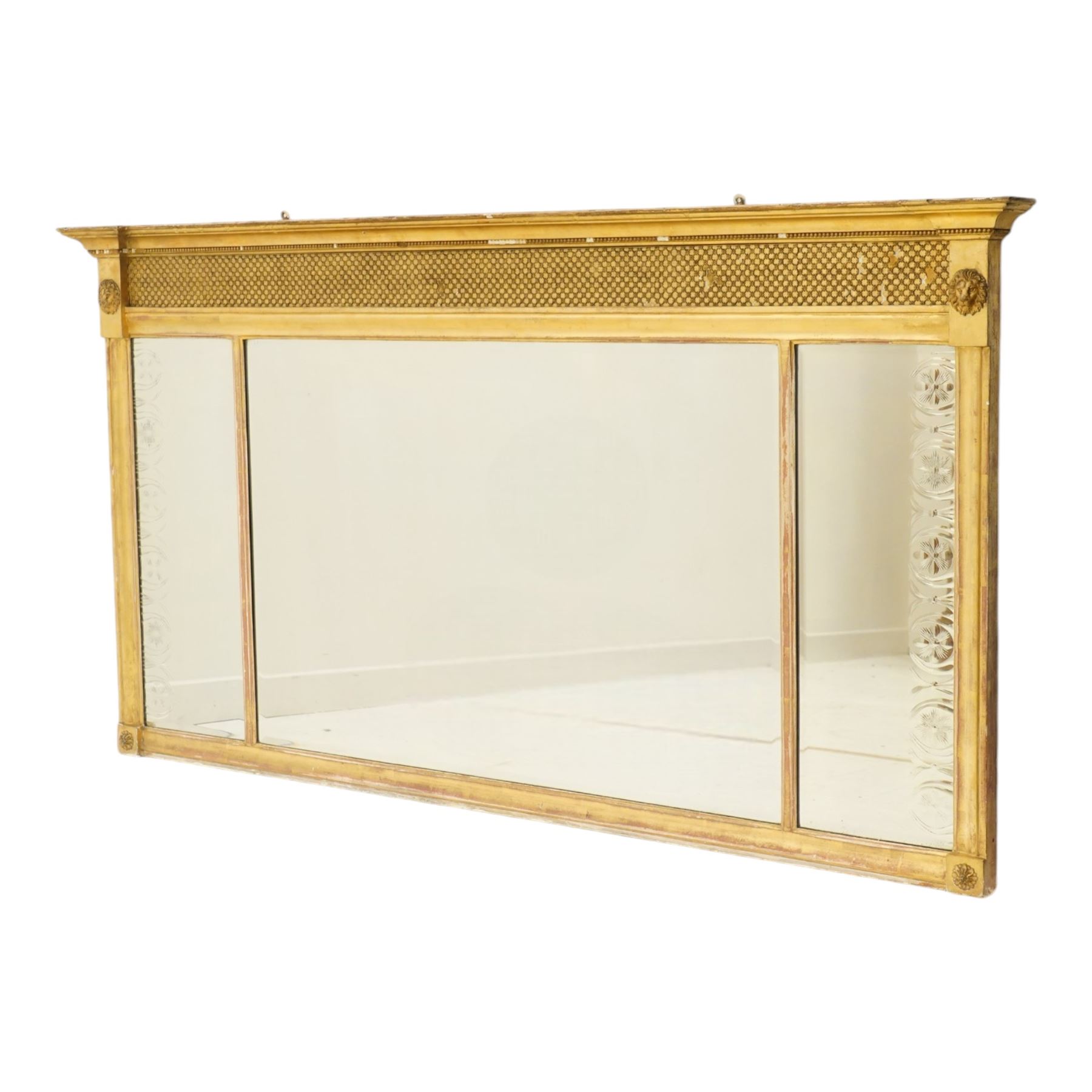Regency style giltwood and composition tripartite overmantel mirror, rectangular frame with stepped cornice above a pierced geometric frieze, central mirror plate flanked by narrow etched floral side plates, with applied rosette paterae and moulded borders