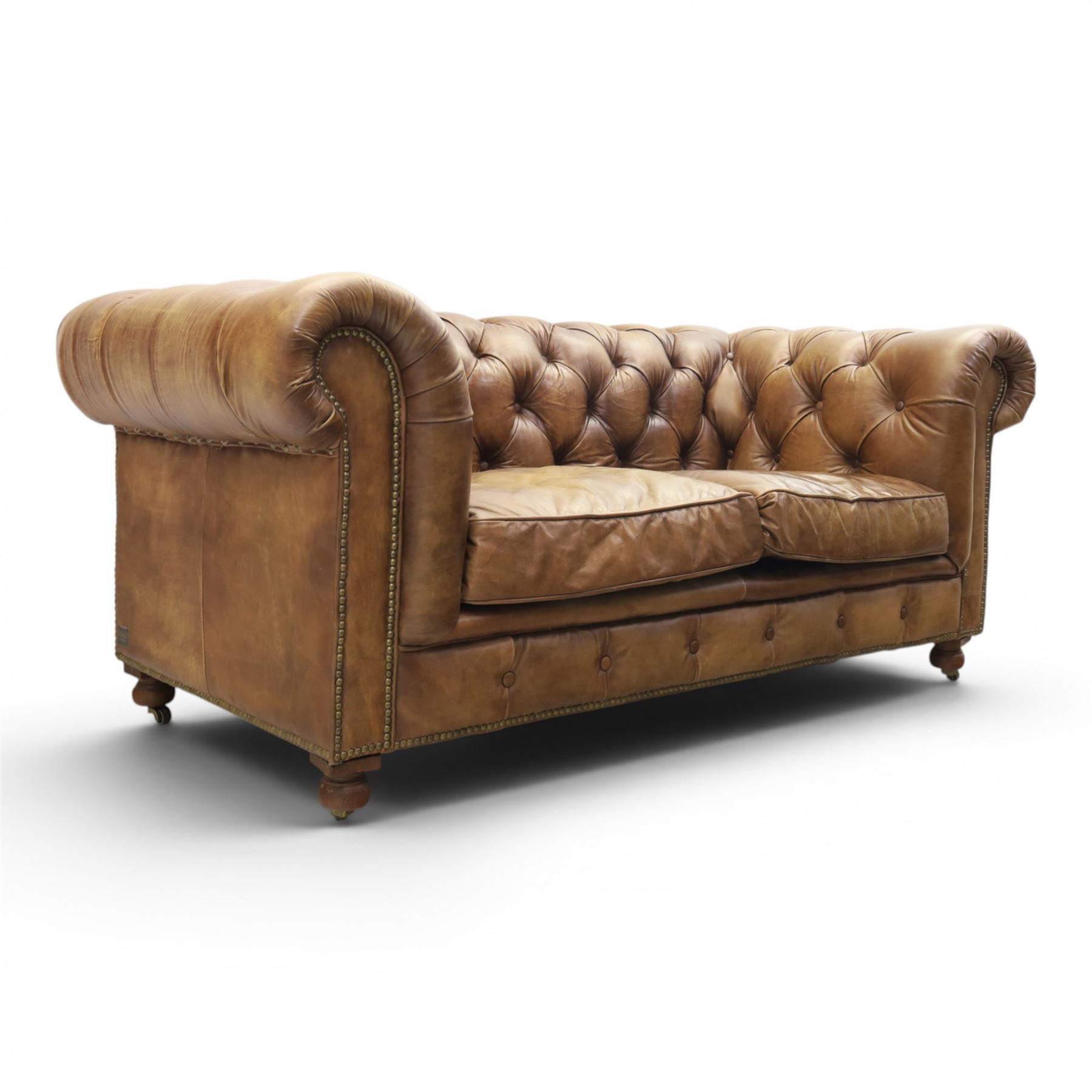 HALO - Chesterfield style two seat sofa upholstered in buttoned brown leather with stud work, on turned feet with castors