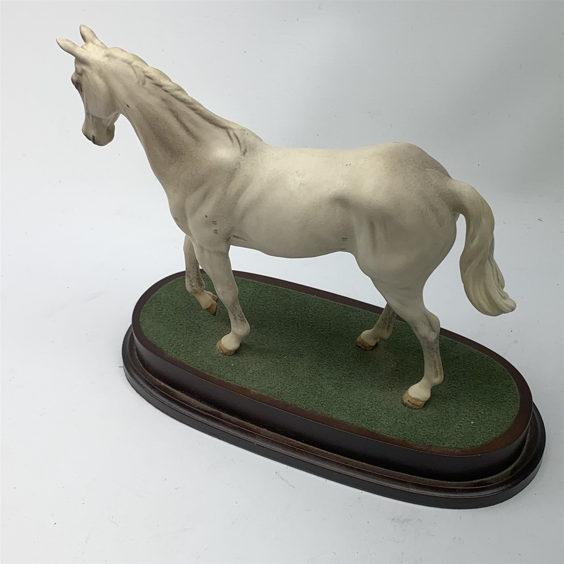 A Royal Doulton figurine modelled as the race horse Desert Orchid, upon a wooden oval base. 