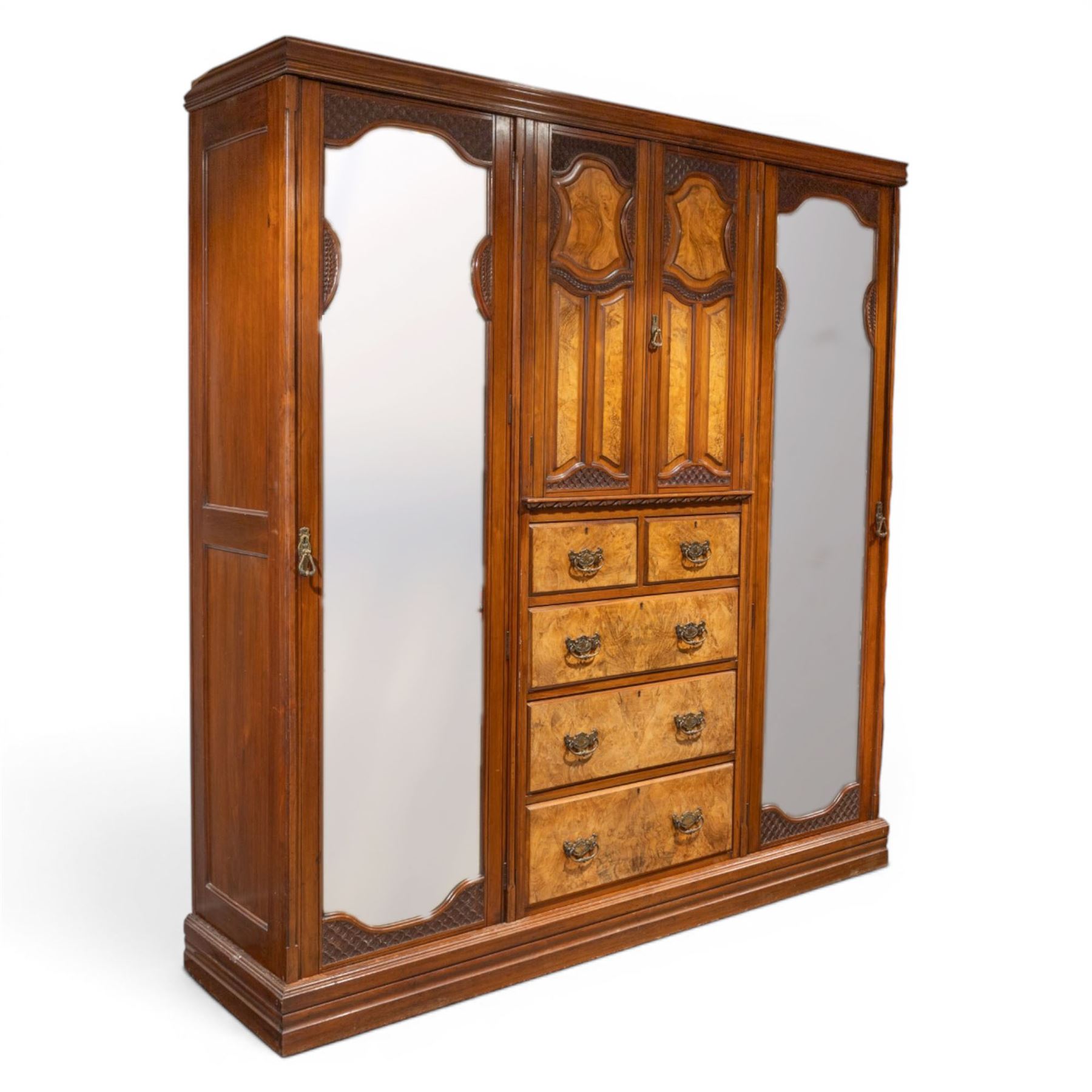 Edwardian figured walnut triple combination wardrobe, moulded cornice above a three part wardrobe, central section with figured walnut panelled doors, above two over three drawers, flanked by mirrored doors enclosing hanging hooks, raised on a plinth
