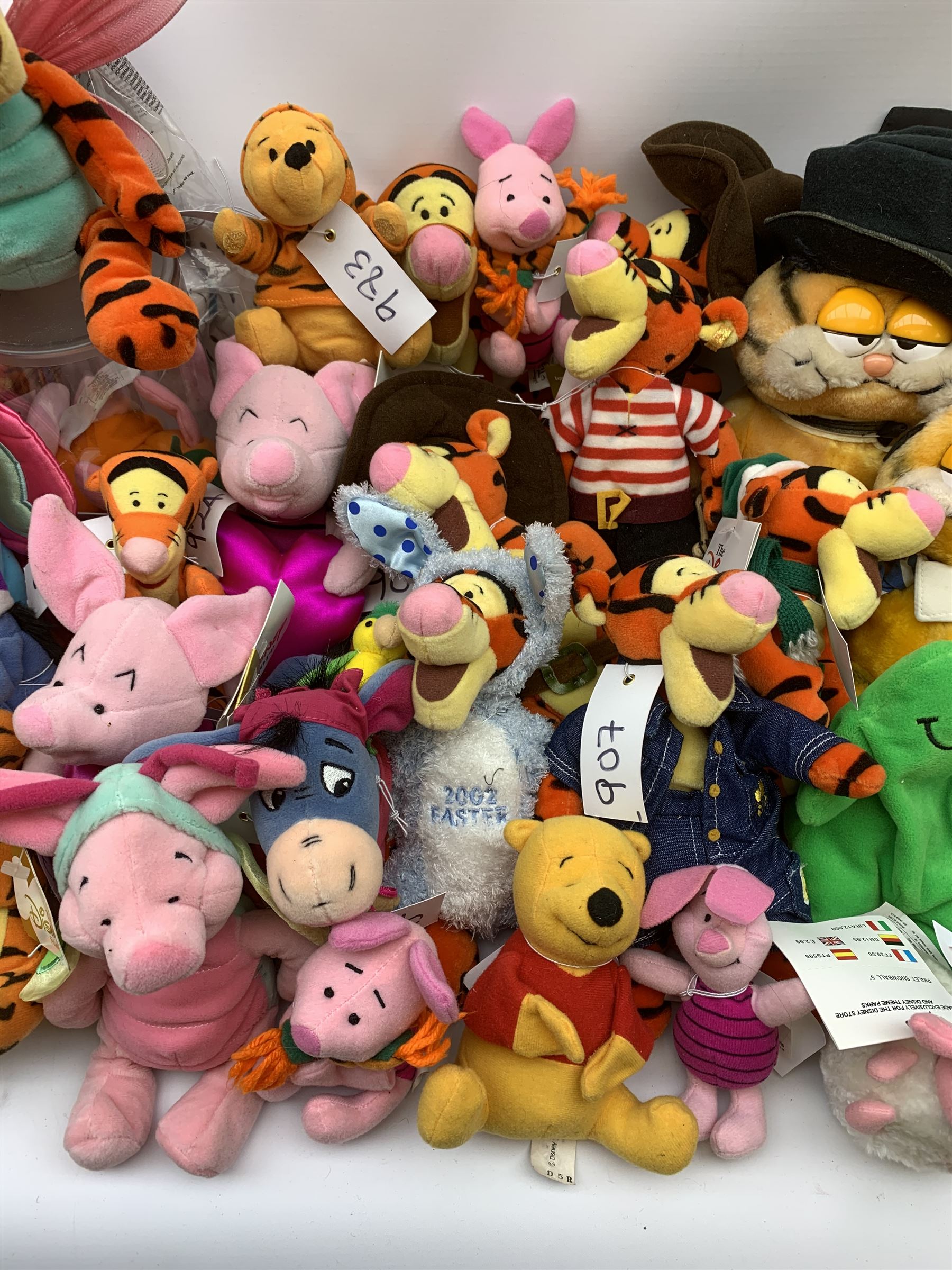Over forty Walt Disney character soft toys including Tigger Pirate, Xmas Tree, Cowboy, Butterfly, Easter Rabbit etc, Eeyore Santa, Butterfly, Pirate etc, Piglet Lovebug, Valentine, Snowball etc; together with seventeen Garfield the Cat soft toys in various character costume including Skier, Graduate, Aviator, car rear window stickers etc
