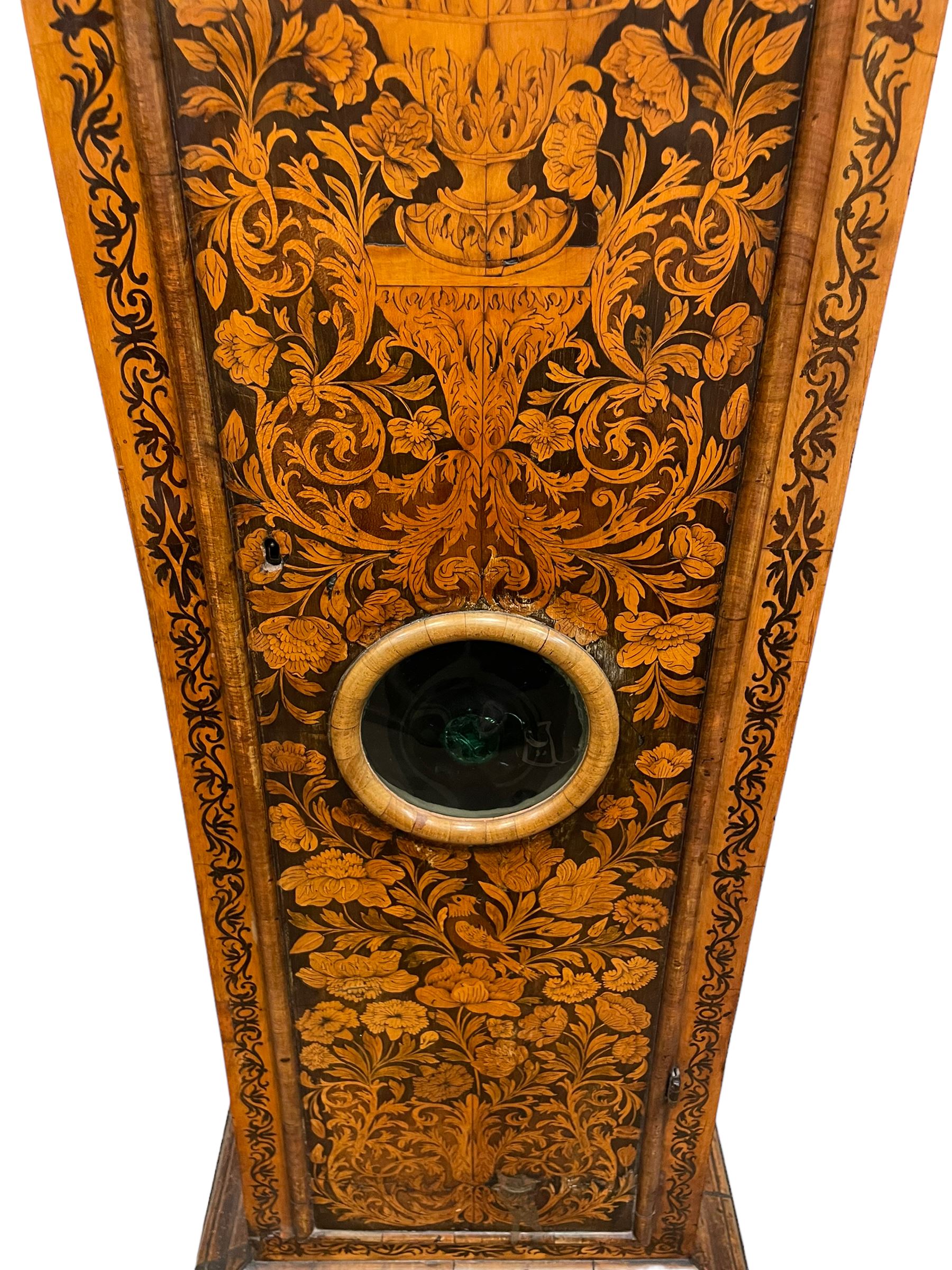 William & Mary floral marquetry 8-day longcase clock c 1700, later mid-18th century four pillar rack striking movement with a square brass dial and subsidiary seconds dial, ringed winding holes and calendar aperture to the matted dial centre, with London cherub head cast spandrels and (later) fretted steel hands, silvered Roman numeral chapter ring with stylised fleur di Lis half hour makers, narrow Arabic five-minutes, minute track and inner quarter hour track, signed Thomas Horlock, Hammersmith, 
case with box upstand to the domed floral marquetry decorated caddy with three brass flame finials, above a moulded cornice and fretwork frieze,  inlaid hood door with attached barley twist pillars to the front above an inlaid convex moulding, full length D moulded trunk door with a circular lenticle inlaid with floral and foliage panels inhabited with birds, on a conforming marquetry plinth with applied double skirting. Thomas Horlock is recorded as a Whitesmith & Clockmaker of Hammersmith, Middlesex.
A copy of Thomas Horlock's will dated the 15th June 1757 is held at The National  Archives Kew.