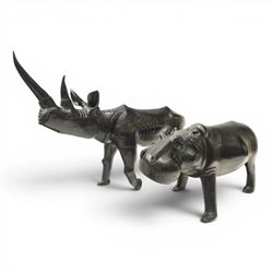 African carved hardwood ebonised figures of a rhinoceros and hippopotamus, each with styli...