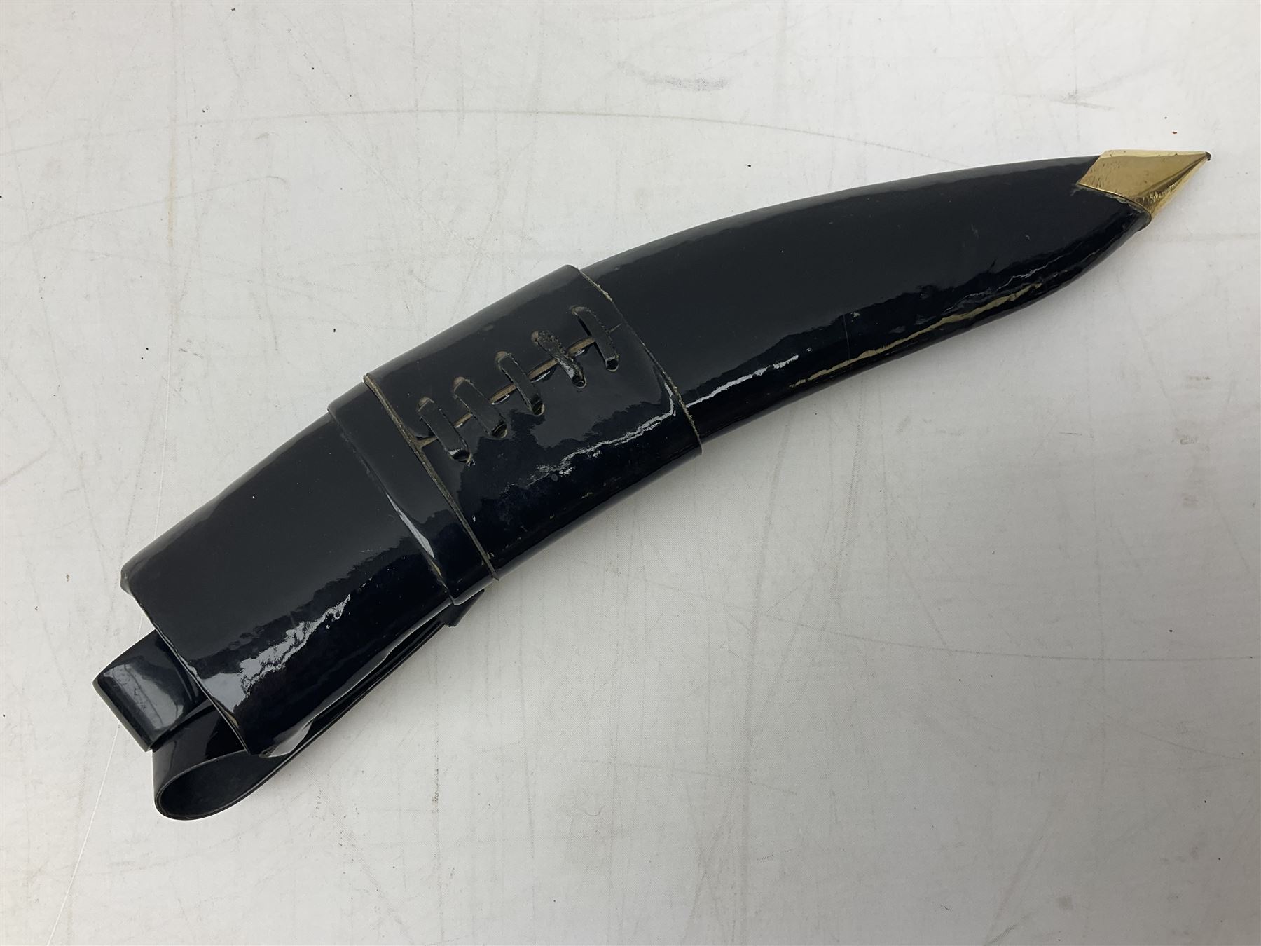 Ceremonial kukri, the 28.5cm curving blade inscribed 'O RDEP NEPAL 9/81' with brass mounted horn grip; in gloss black scabbard with two skinning knives 41cm overall