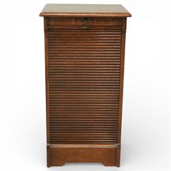 Early 20th century oak filing cabinet, the rectangular top with moulded edge above a tambour shutter enclosing a fitted interior with eleven shaped filing shelves, the sides with shaped uprights, raised on a plinth base