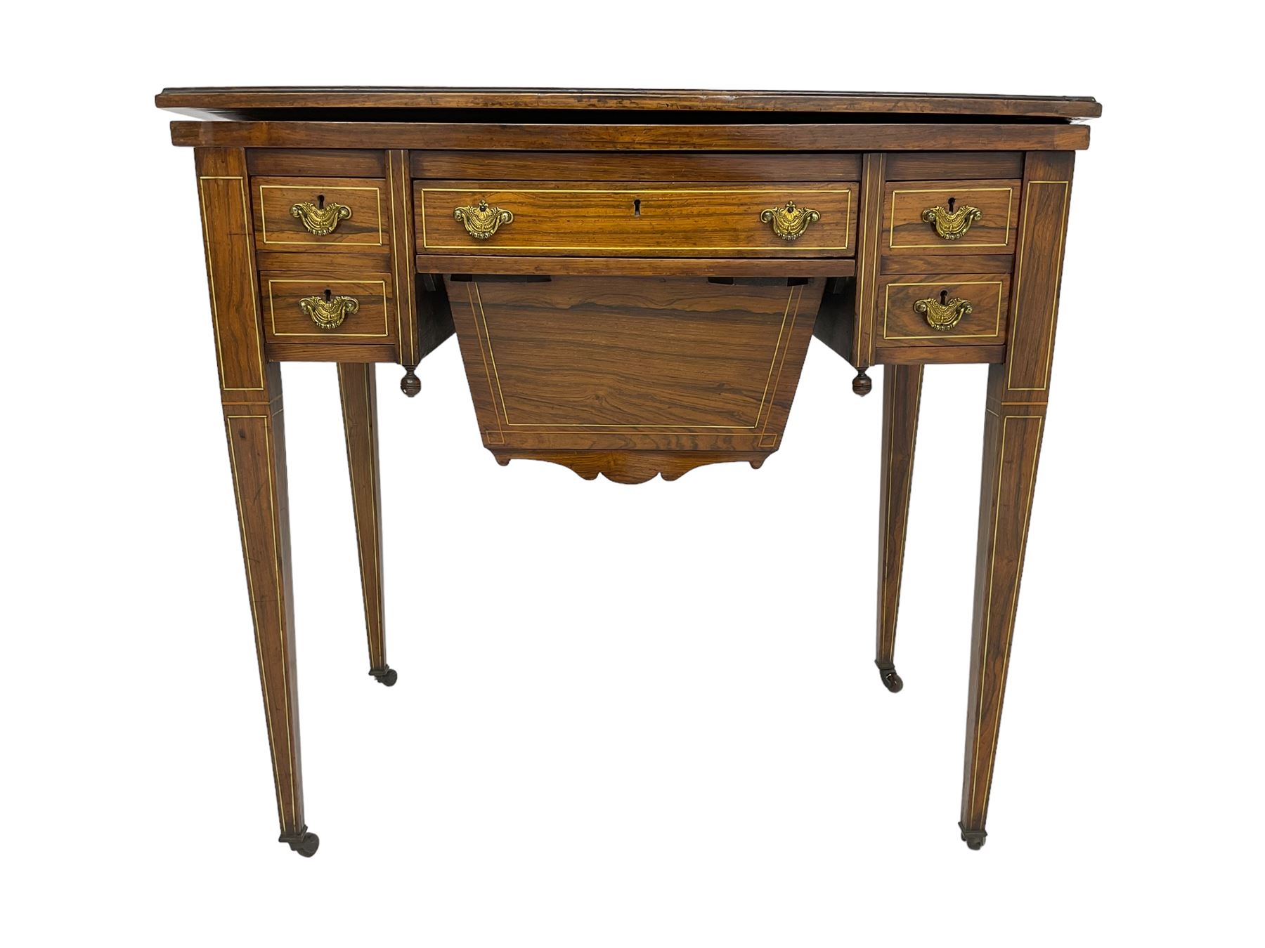 Edwardian inlaid mahogany games or work table, rectangular fold-over top inlaid with stylised dragon ivorine decoration and stringing, fitted with one long flanked by four small drawers over sewing compartment drawer, raised on square tapering supports with castors
