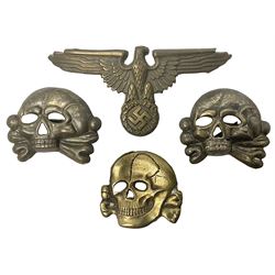 Two WW2 German 'SS' visor cap skull badges and another later; and visor cap eagle insignia (4)