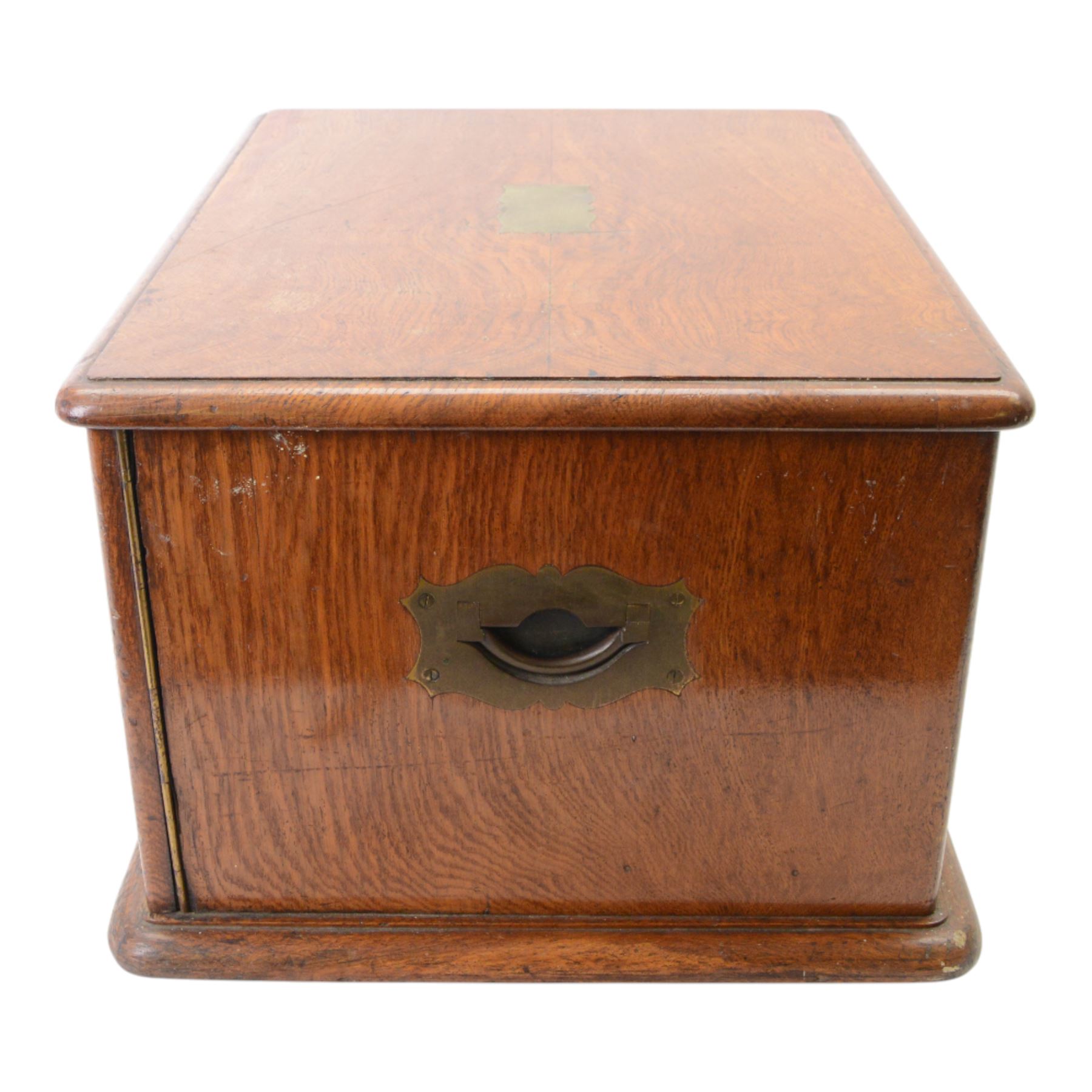 Oak table top canteen cabinet, the top with inset vacant brass cartouche, with pair of panelled doors opening to reveal four interior drawers with inset brass handle, containing a selection of silver plated flatware, 29cm x 40cm x 51cm