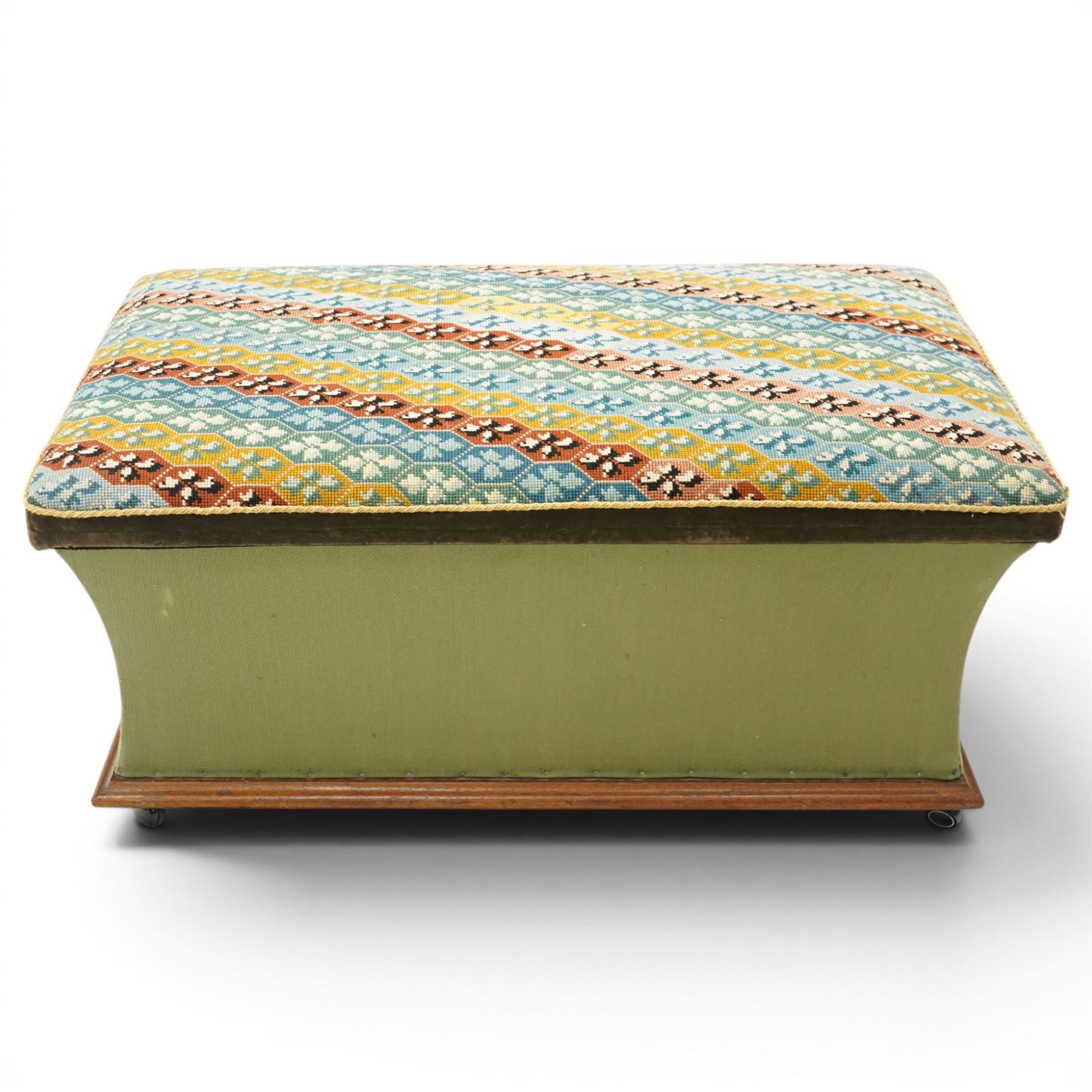 Victorian Ottoman with tapestry cover, with multicoloured geometric needlepoint cover, hinged to reveal a pink paper lined interior, the base covered in green velour fabric, raised on later castors