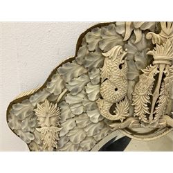 Pair 19th century French Dieppe bone and ivory wall mirrors, the oval bevelled mirror plates within rectangular frames with shaped tops, profusely decorated with ivory leaves, further detailed with carved bone armorial type crest inscribed 'SGOTORVM', putti, fish and mask heads, H81cm W48cm