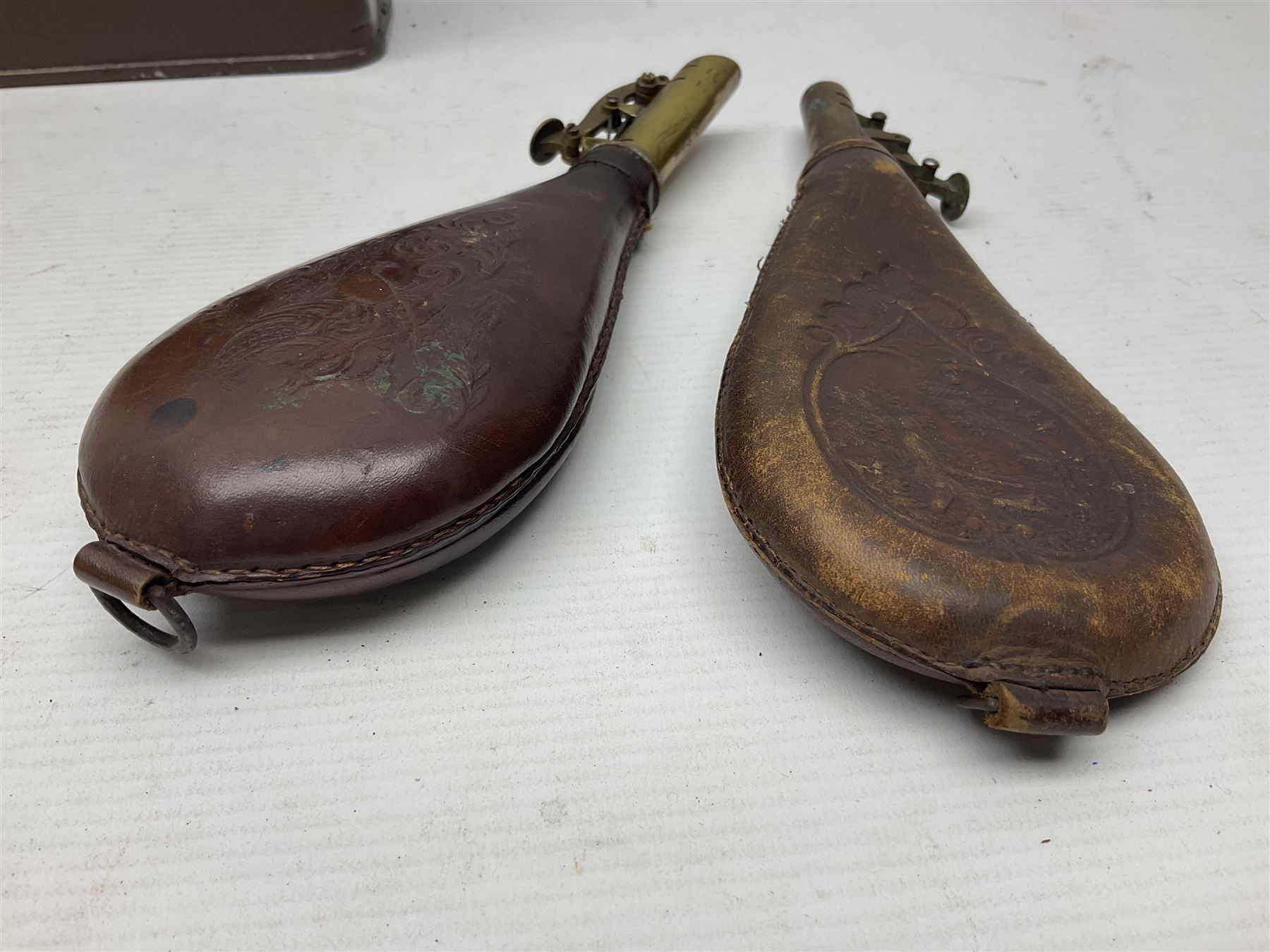 Two leather shot flasks with embossed decoration and brass nozzles; scissor action bullet mould with two ladles; pair of 19th century J.B. Warrilow hammer actions; small quantity of Staybrite buttons; and 1968 dated metal ammunition tin for 200 x 7.62 blank cartridges