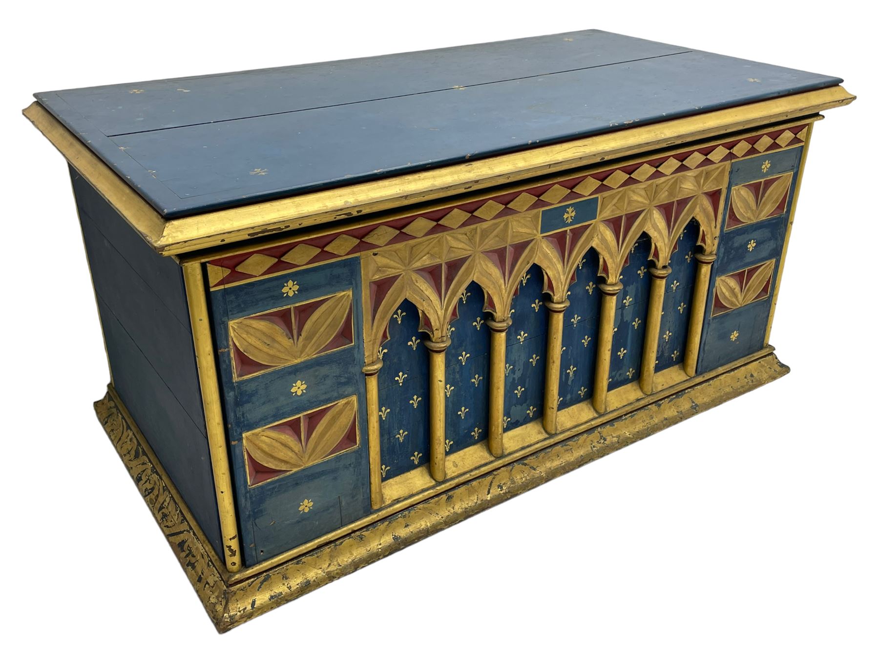 In the manner of William Burges - mid-to-late 19th century English Gothic Revival pine altar or console table, in blue and red paint with water gilding, the moulded rectangular top over six pointed arches with turned column supports, the front carved with a single row of lozenges and incised stylised motifs