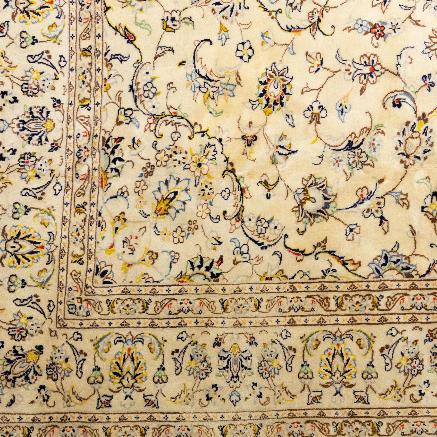 Central Persian Kashan hand-knotted carpet, ivory ground, with a central shaped floral medallion with pendants, surrounded by scrolling foliate and floral motifs incorporating rosettes, palmettes and delicate vine work, enclosed by a conforming ivory border with repeating palmettes and meandering vines, flanked by floral guard stripes, with cotton fringes