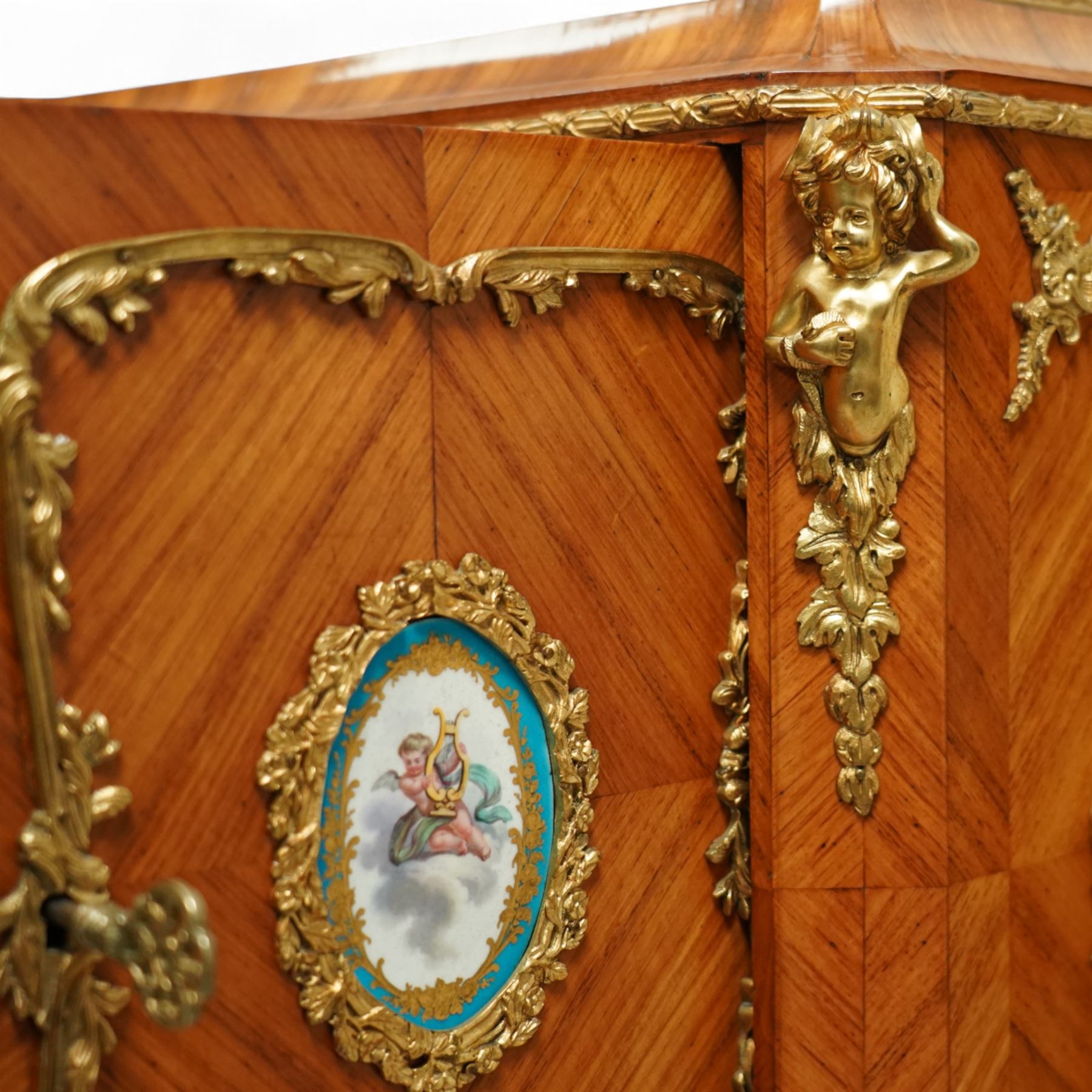 Late 19th century French Louis XV style kingwood and ormolu mounted bonheur du jour, the upper section with a pierced three-quarter gallery over a pair of cupboard doors inset with Sèvres-style porcelain portrait plaques, enclosing a shelved interior over two short drawers, the serpentine top and apron richly mounted with gilt-bronze foliate and scroll motifs, single frieze drawer below on cabriole supports with acanthus cast sabots