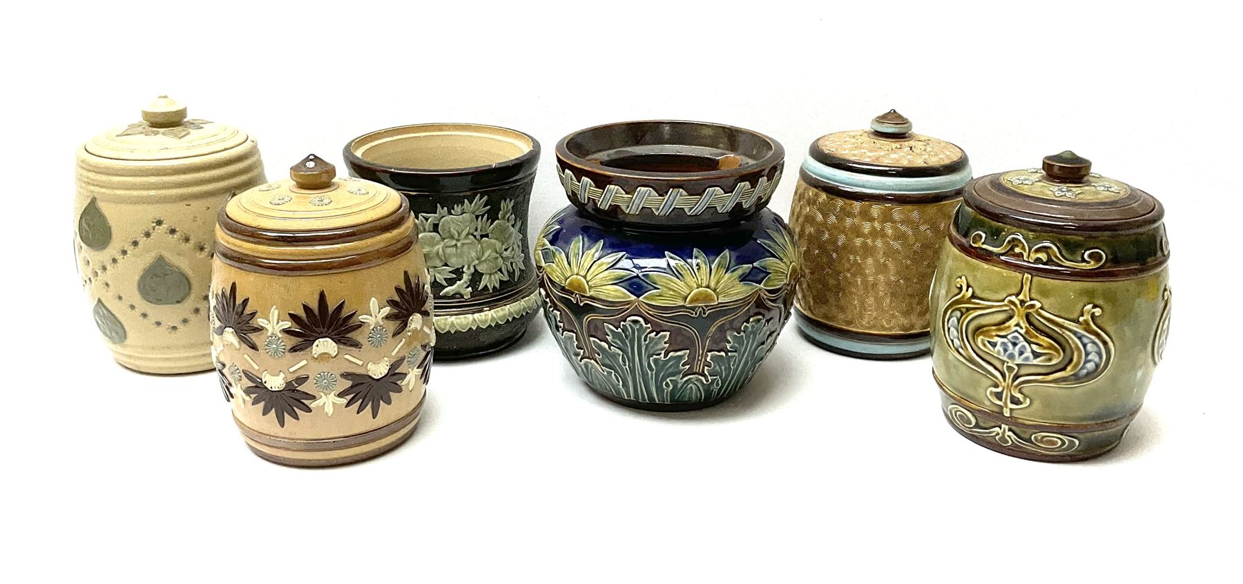 A group of Doulton Lambeth and Royal Doulton tobacco jars, to include examples with relief moulded foliate decoration, each with impressed marks and markers monograms beneath. 