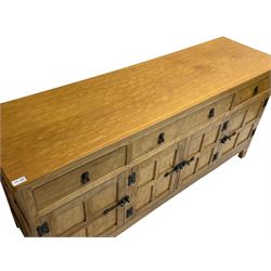 Acornman - adzed oak sideboard, fitted with three drawers and four cupboards enclosed by panelled doors, all-over adzing and iron fixtures, with acorn signature to lower front foot, by Alan Grainger of Brandsby