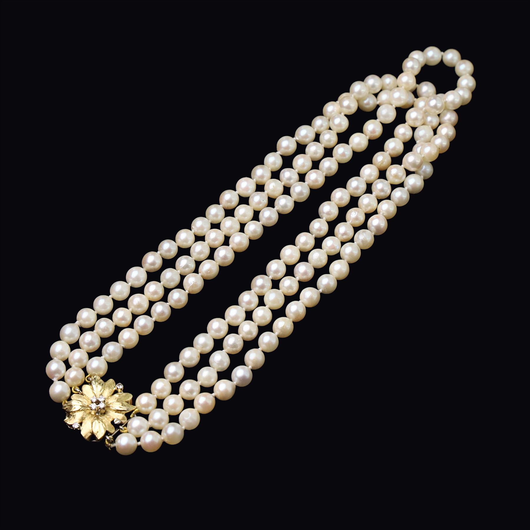 Three strand cultured white / cream pearl necklace, with an 18ct gold diamond set leaf design clasp