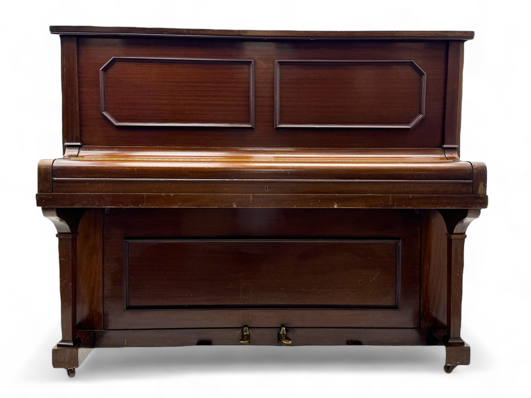 Waddington - Edwardian mahogany upright piano, rectangular top with panelled front, rounded key cover, makers name on fallboard, raised on bracket supports with castors