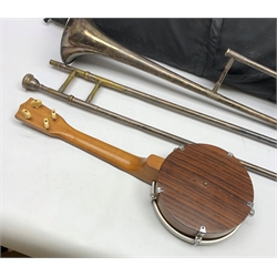  Hawkes & Son 'Artist's Perfected' silver-plated trombone with mouthpiece, no. 57481, L117cm in damaged carrying case and small 4-string banjo ukulele L53cm (2)  
