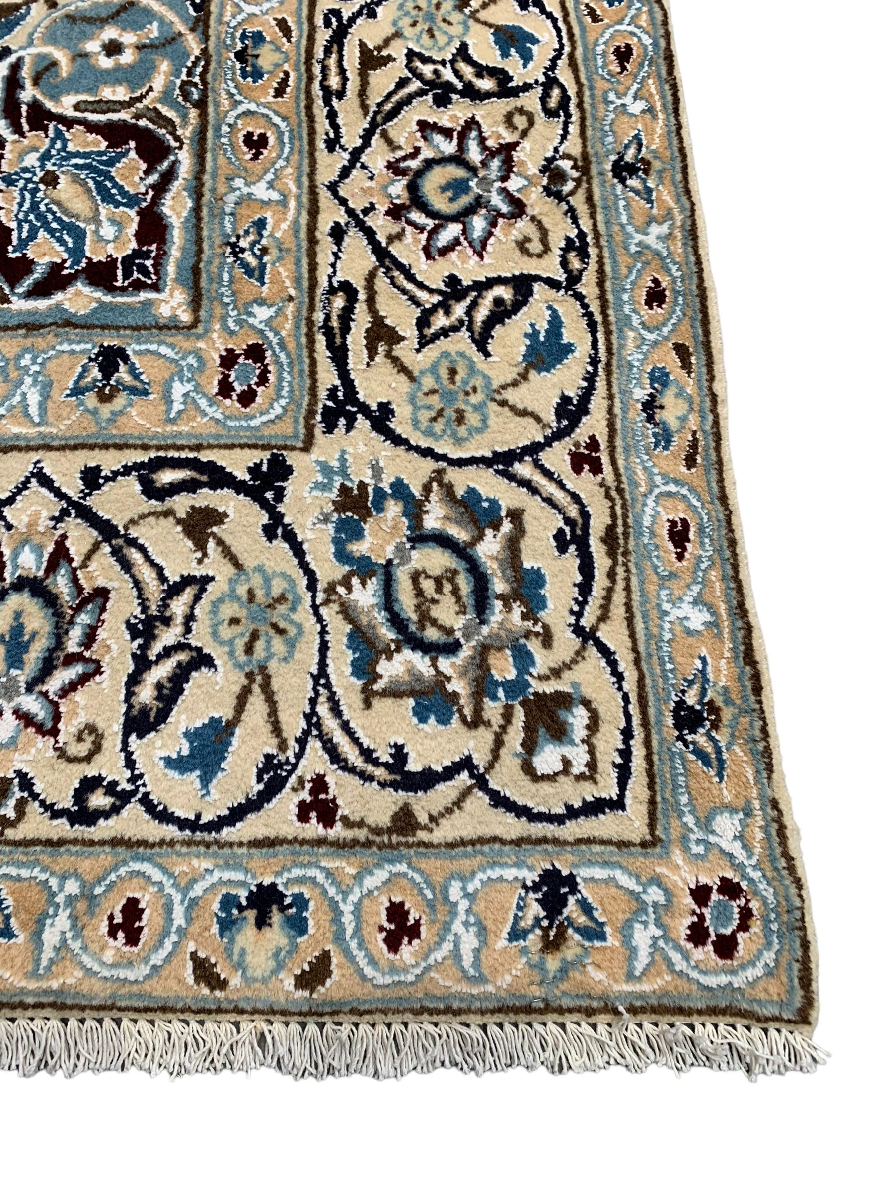 Persian Kashan ivory ground rug, central medallion surrounded by scrolling leafy branches and stylised flowerhead motifs, scrolling border decorated with further stylised plant motifs