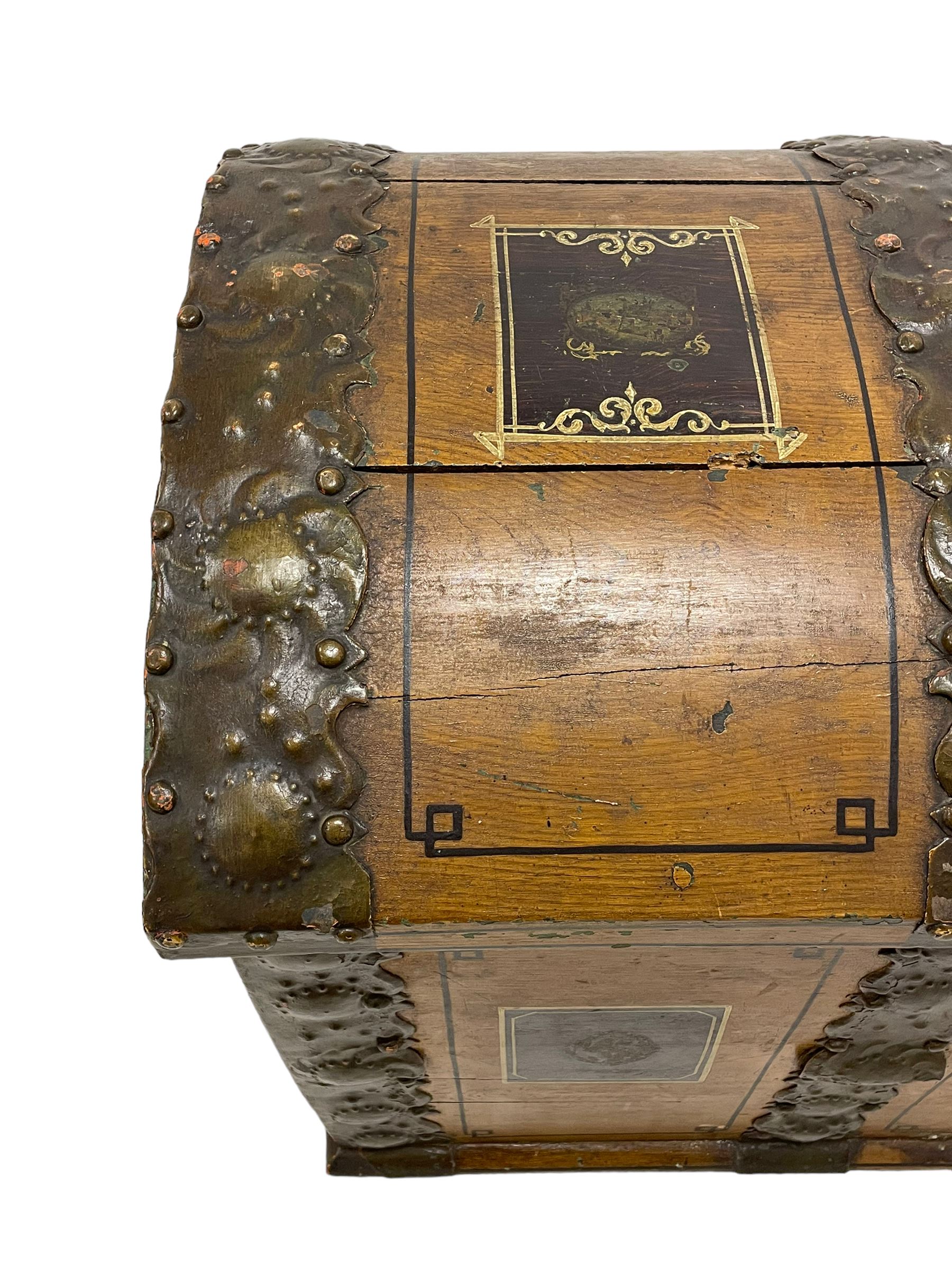 19th century painted oak sea chest, hinged dome top enclosing small compartment, bound by shaped and pressed metal strapwork, scumbled finish to resemble oak and painted with small vignettes depicting portraits and landscapes within panels, fitted with large wrought metal carrying handles, the front inscribed 'H.J.S. 1870' 