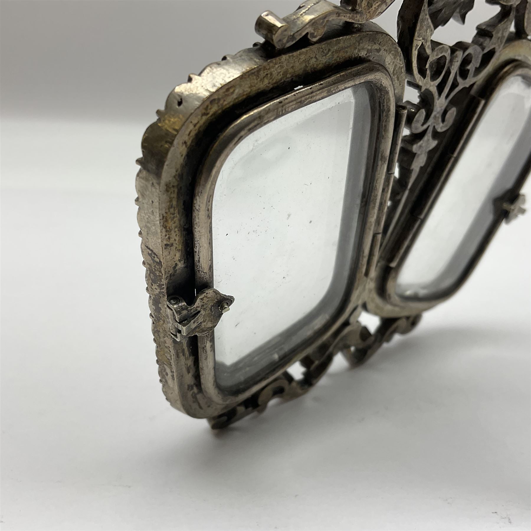 Early 19th century silver plated double photograph frame, each rounded rectangular aperture surrounded by a paste border, with ornate scroll feet and mantling also set with clear paste stones, with easel style support verso, H12cm