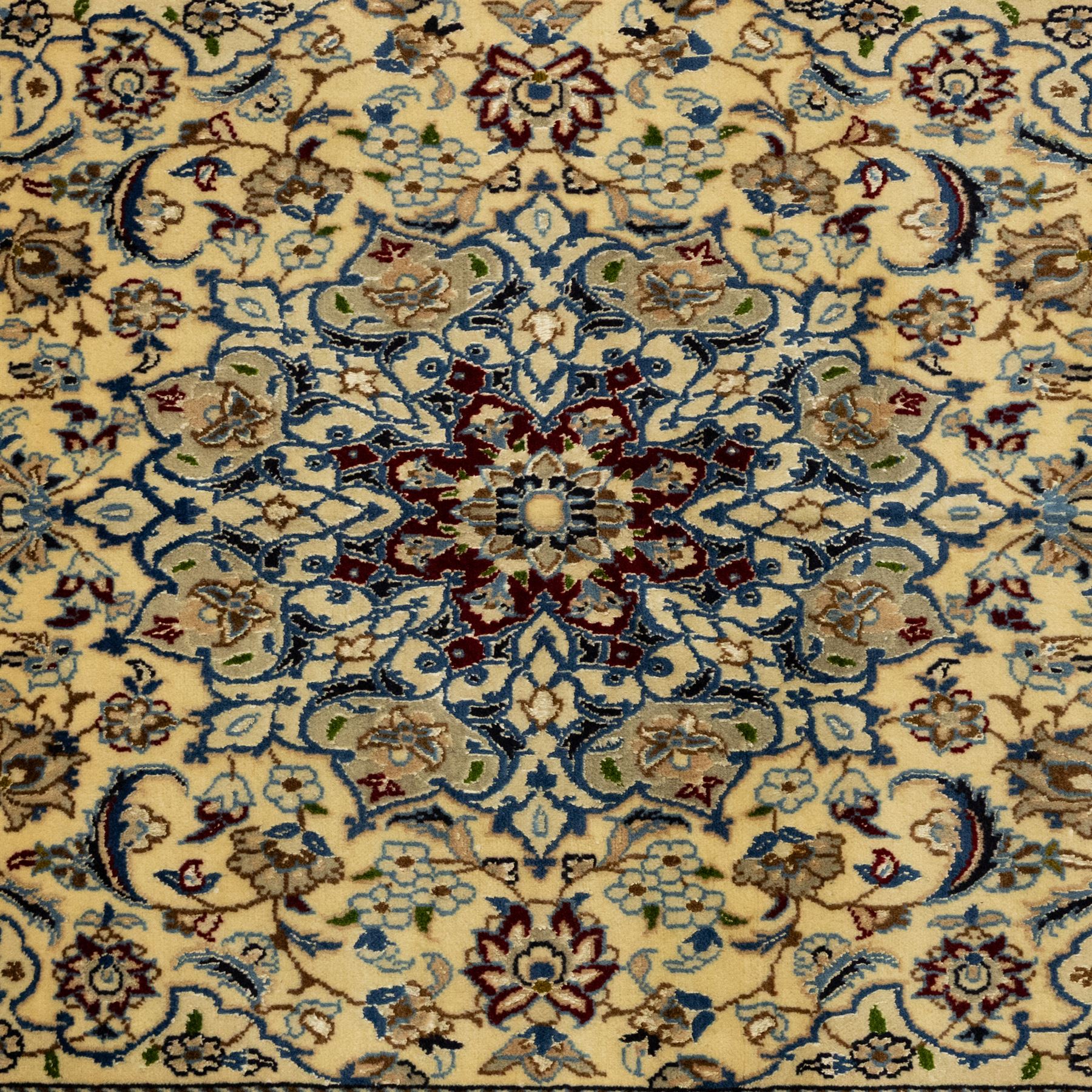 Central Persian fine Nain hand-knotted rug, ivory ground, with a central shaped floral medallion with pendants, surrounded by scrolling foliate and floral motifs incorporating rosettes, palmettes and delicate vine work in blue, cream and beige tones, enclosed by blue spandrels and an ivory border with repeating palmettes and meandering vines, flanked by floral guard stripes, with cotton fringes
