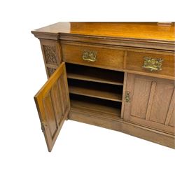 Edwardian oak dresser, the raised back supported by four corbels relief carved with scrolling branch and foliage, moulded top over three drawers, three cupboards below enclosed by panelled doors, the upright carved with foliage motifs, on moulded plinth base