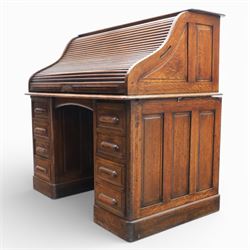 Globe Wernicke - Oak roll top desk, tambour roll top enclosing a fitted interior, raised on two pedestal bases with fitted drawers, raised on a plinth base 