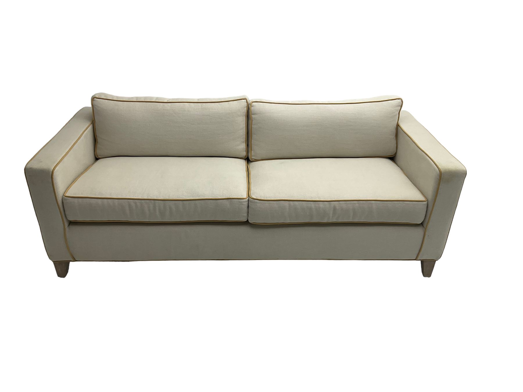 Neptune - pair three seat 'Shoreditch' sofas,  upholstered in cream fabric with yellow stringing