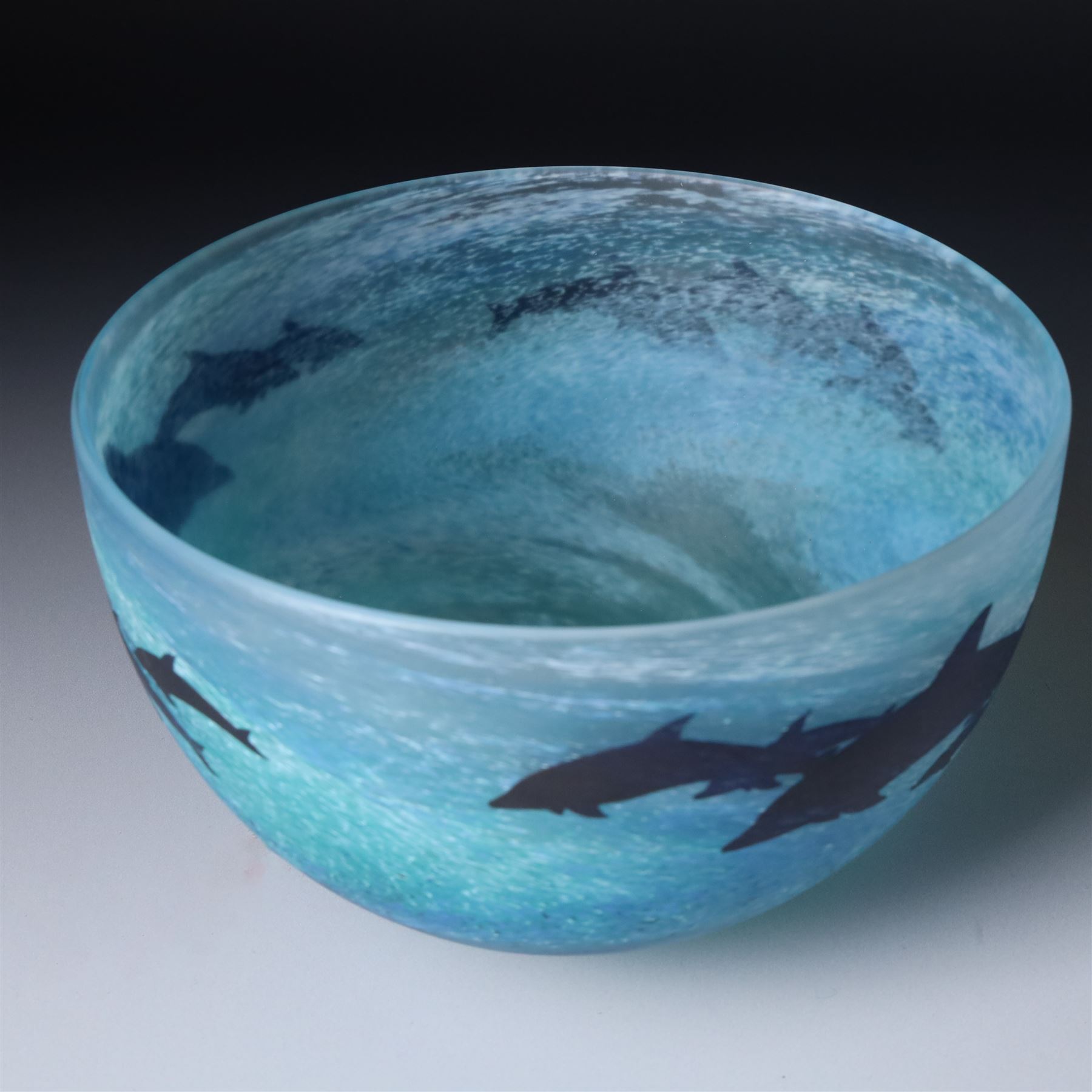 Malcolm Sutcliffe (British 1954-): Studio glass cameo bowl, the body mottled and speckled with shades of blue decorated with dolphins, etched signature, D18cm and matching paperweight (2)