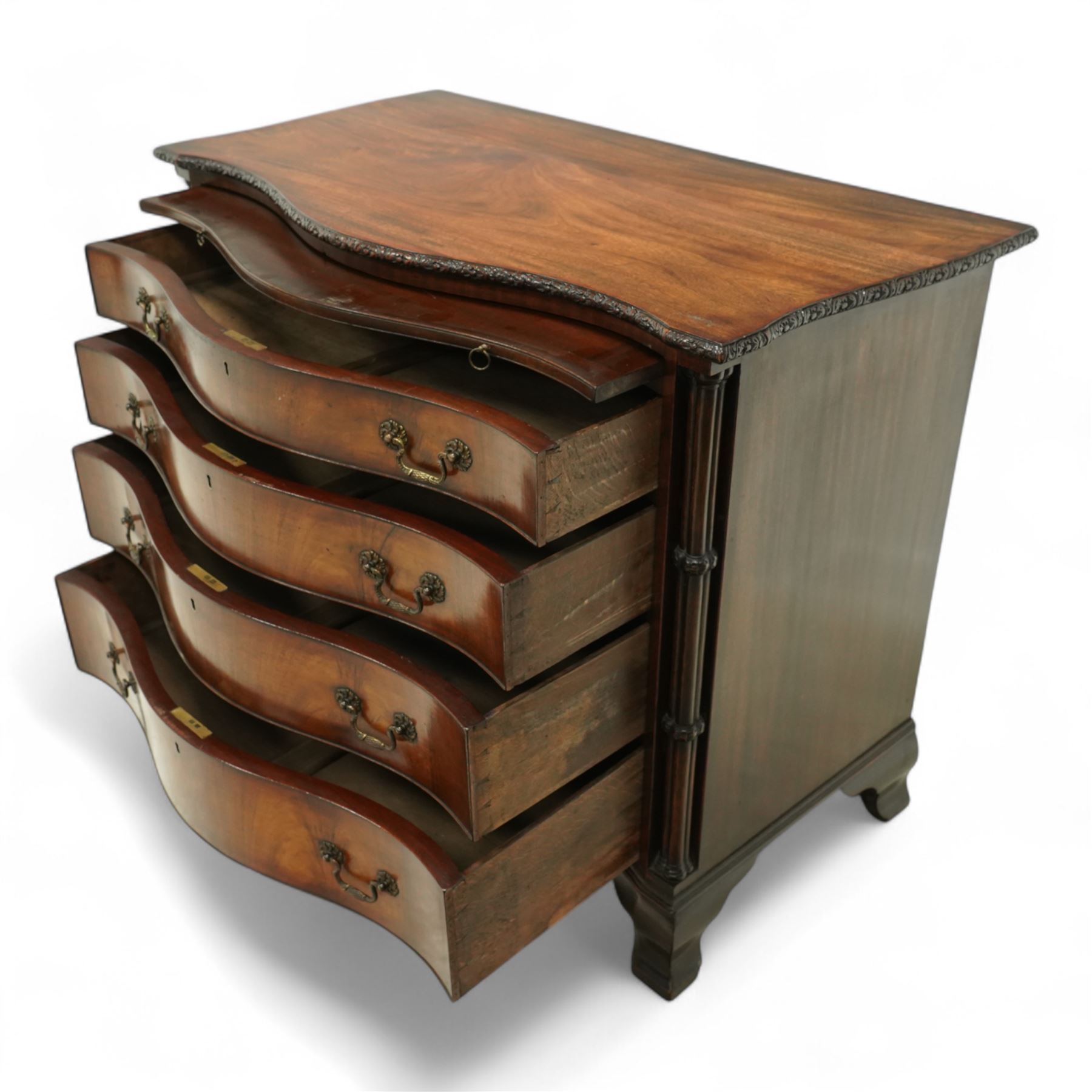 Georgian design mahogany serpentine chest, with rectangular top with floral rosette carved edge, cluster reeded columns with brush slide above four graduated drawers on ogee bracket feet 